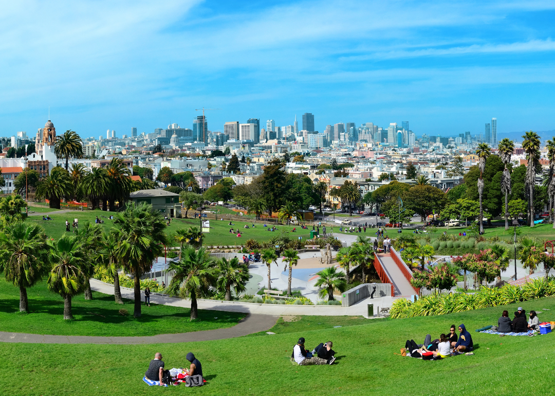 People on blankets in a park with San Francisco in the background.