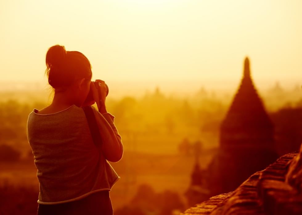 Female traveler photographing temples.