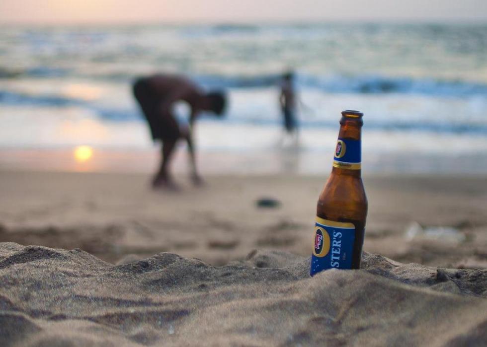 Foster's beer bottle on a sandy beach.