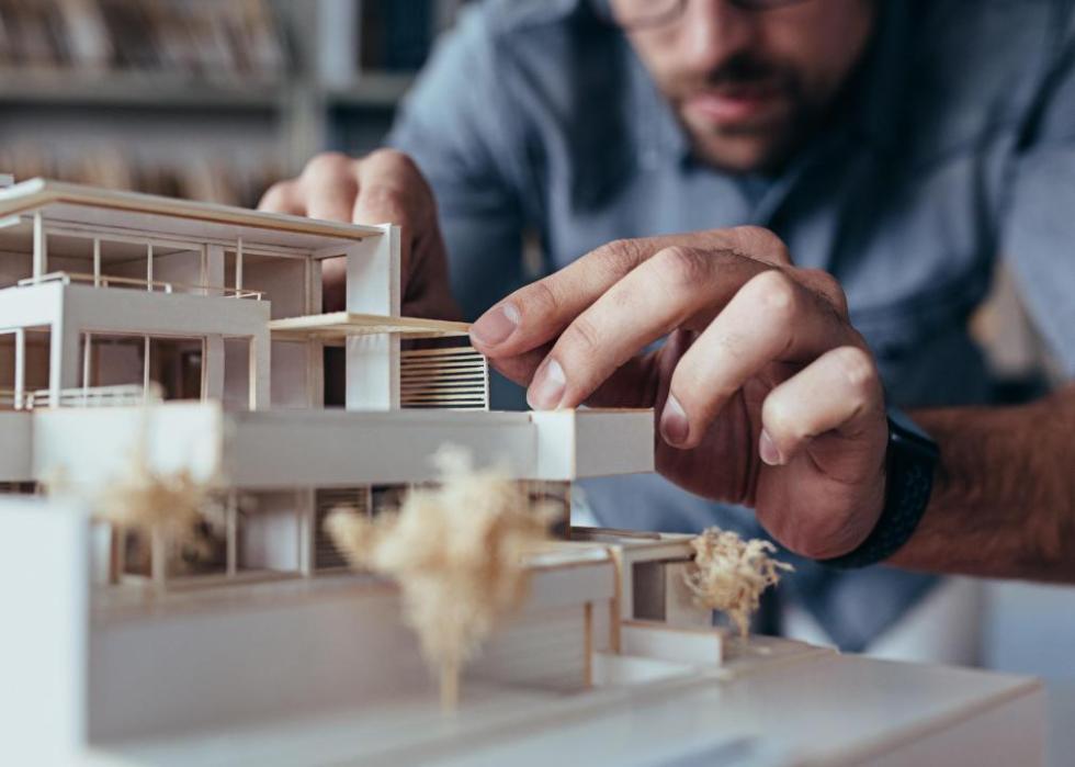 A man working on a model of a building.