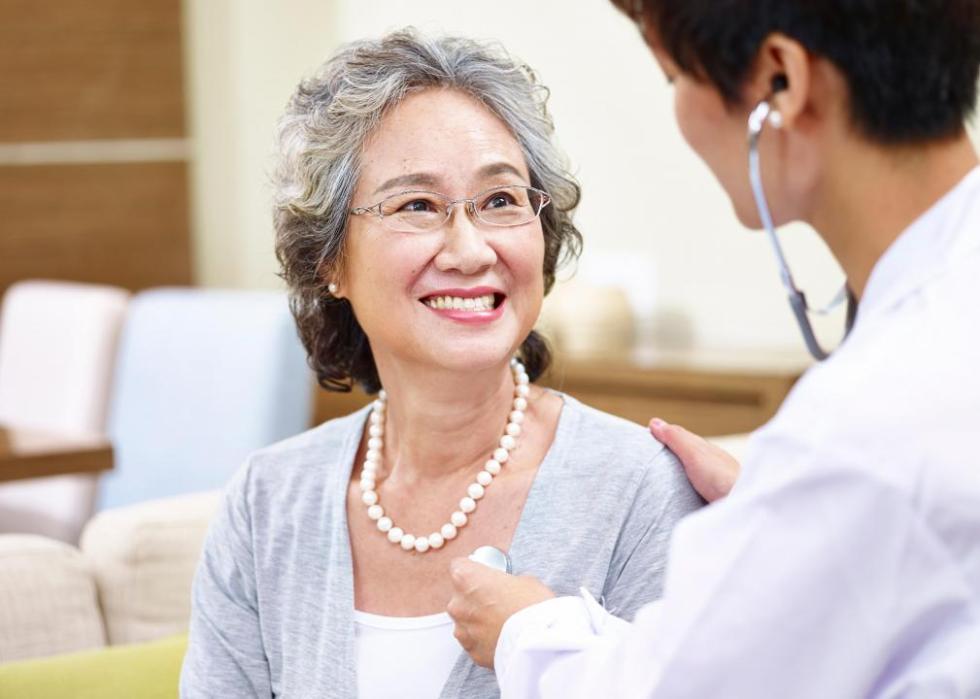 A physician listening to a woman's heart.