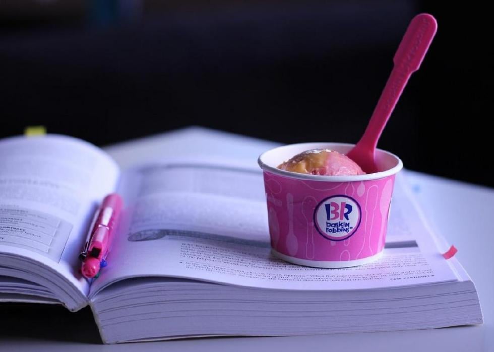 A pink cup of Baskin-Robbins ice cream sitting on a textbook.
