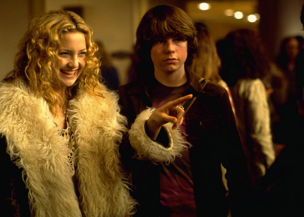 Kate Hudson and Patrick Fugit talking to someone in a scene from Almost Famous.
