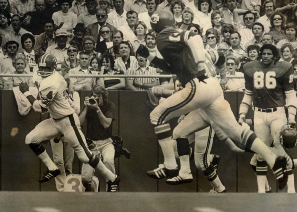 Floyd Little (left) of the Denver Broncos looks back at Emmitt Thomas of Kansas City on the way to a 50-yard touchdown run, 1973.