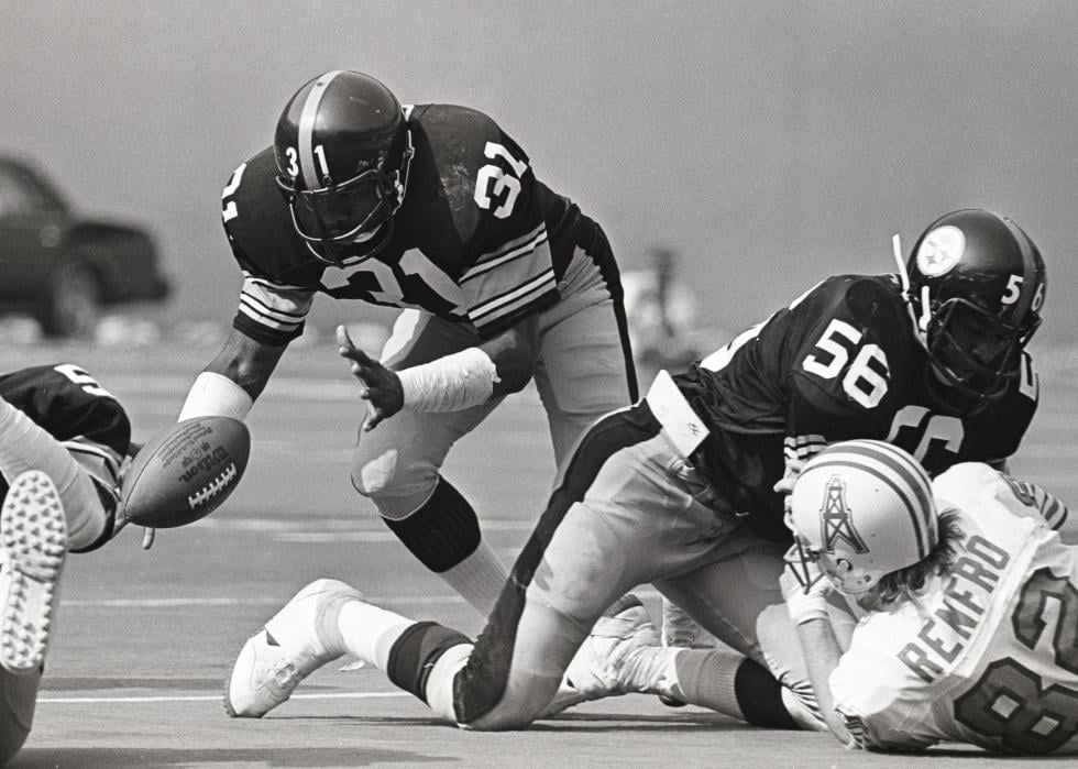 Safety Donnie Shell #31 of the Pittsburgh Steelers reaches for a loose ball as linebacker Robin Cole #56 tackles wide receiver Mike Renfro #82 of the Houston Oilers at Three Rivers Stadium, 1979.
