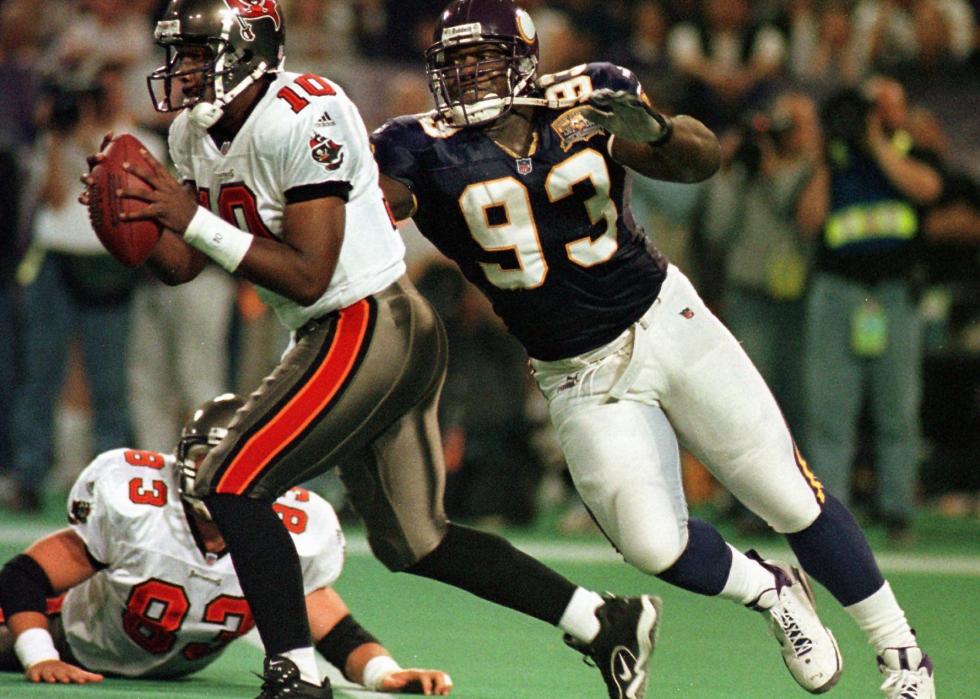 Minnesota Vikings John Randle (C) gets past Tampa Bay Buccaneers lineman Dave Moore (on ground) and chases Shaun King (L) out of the pocket forcing King to throw the ball away in the the first quarter of their game at the Metrodome in Minneapolis, MN on October 9, 2000.