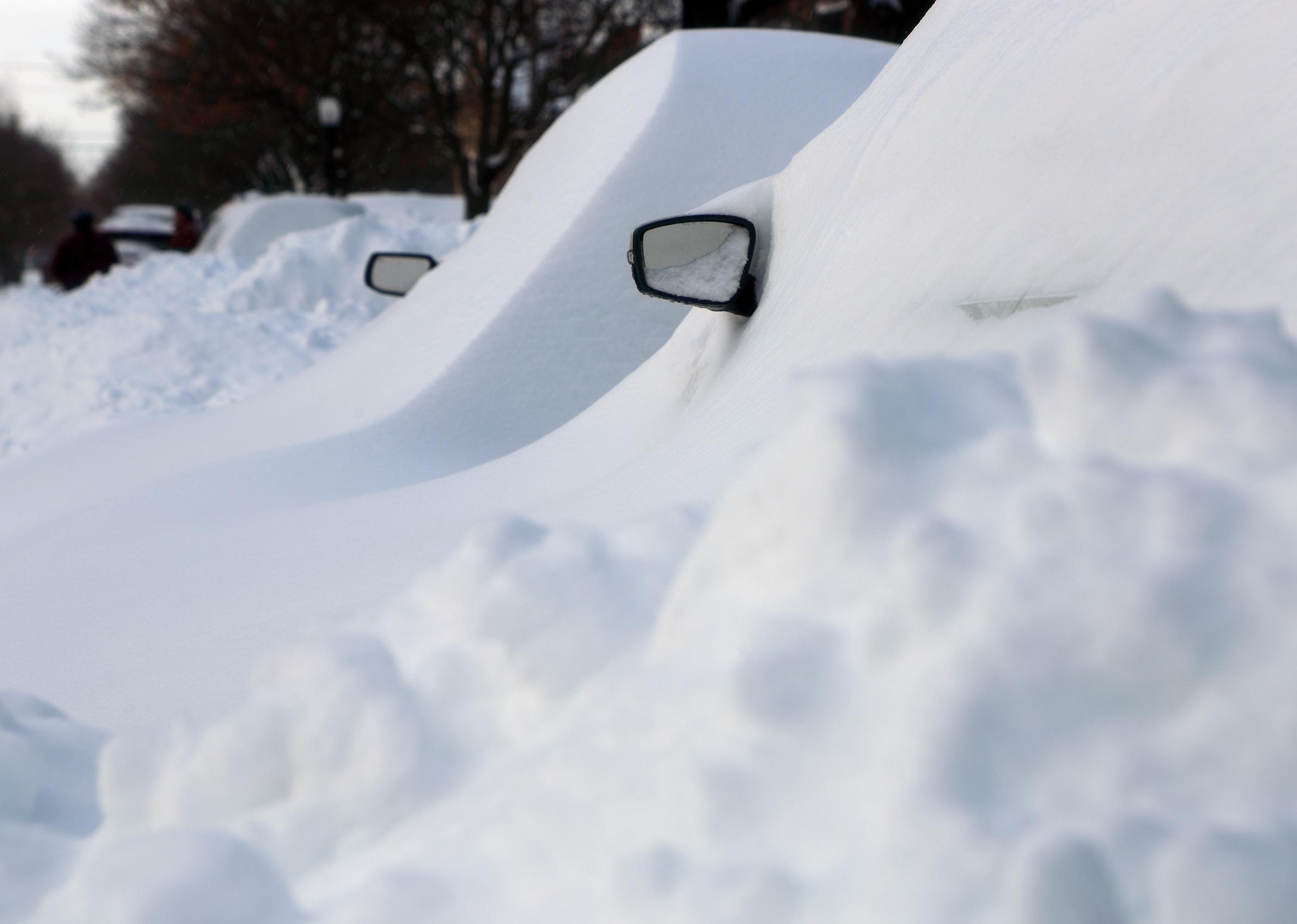 Vehicles covered with snow after a winter blizzard.
