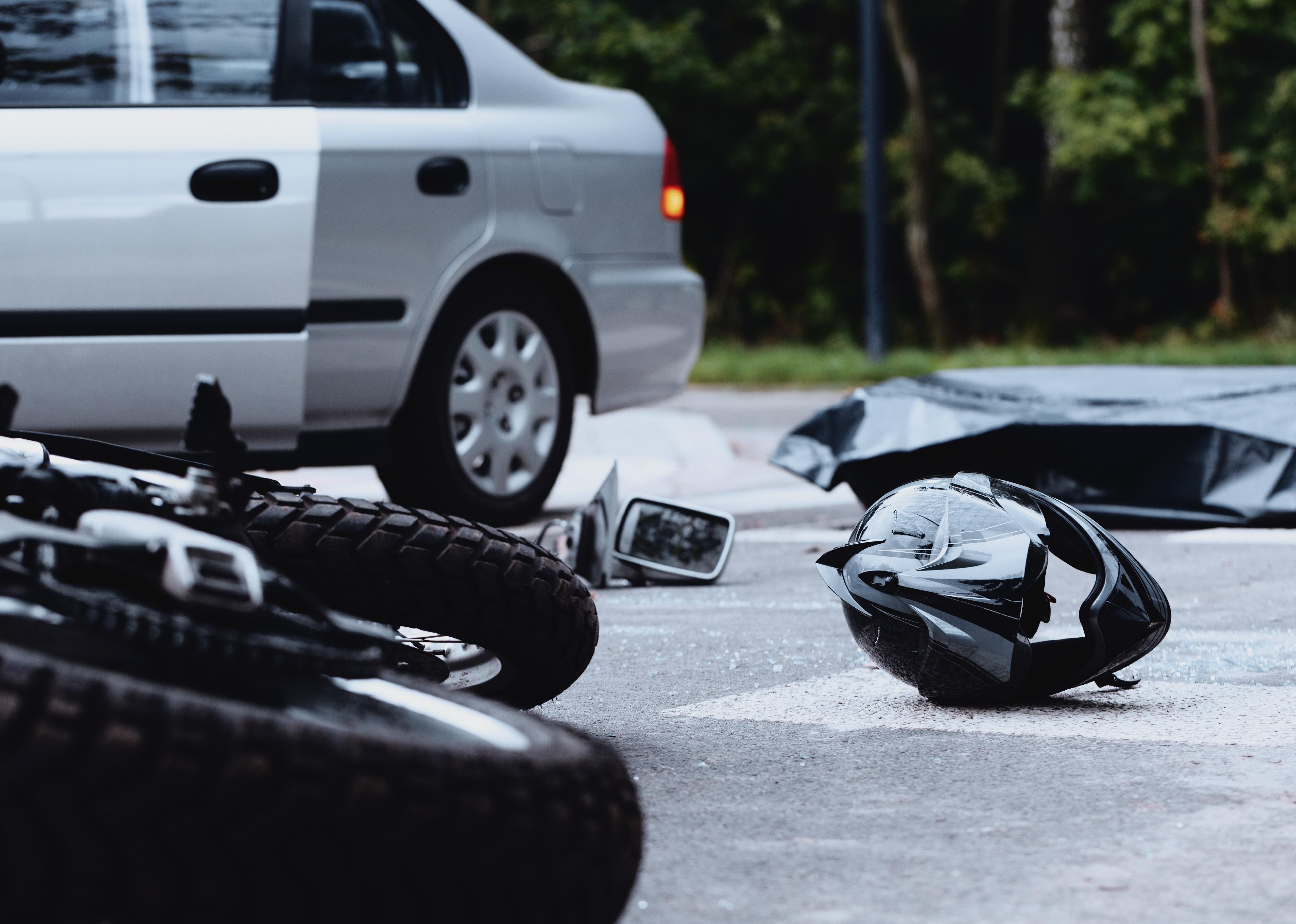 Motorcycle helmet on the street after a fatal accident with a car.