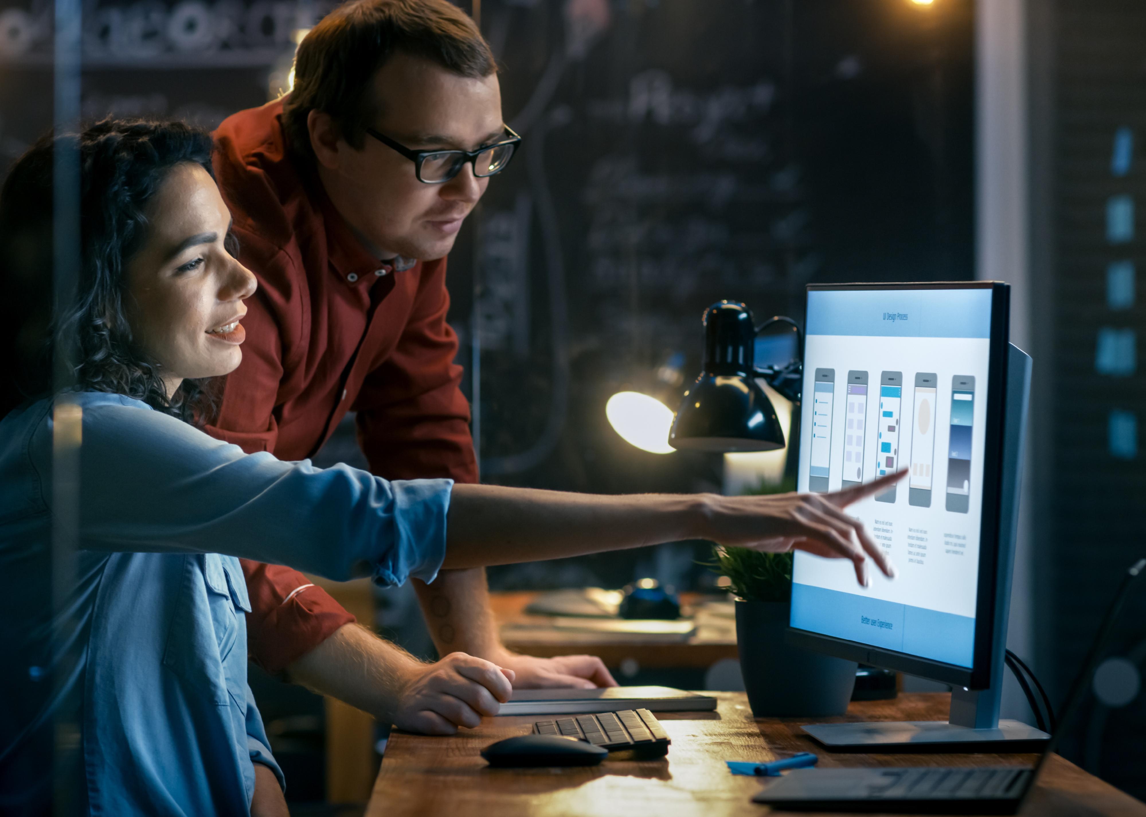 Two people work on app layout on computer.