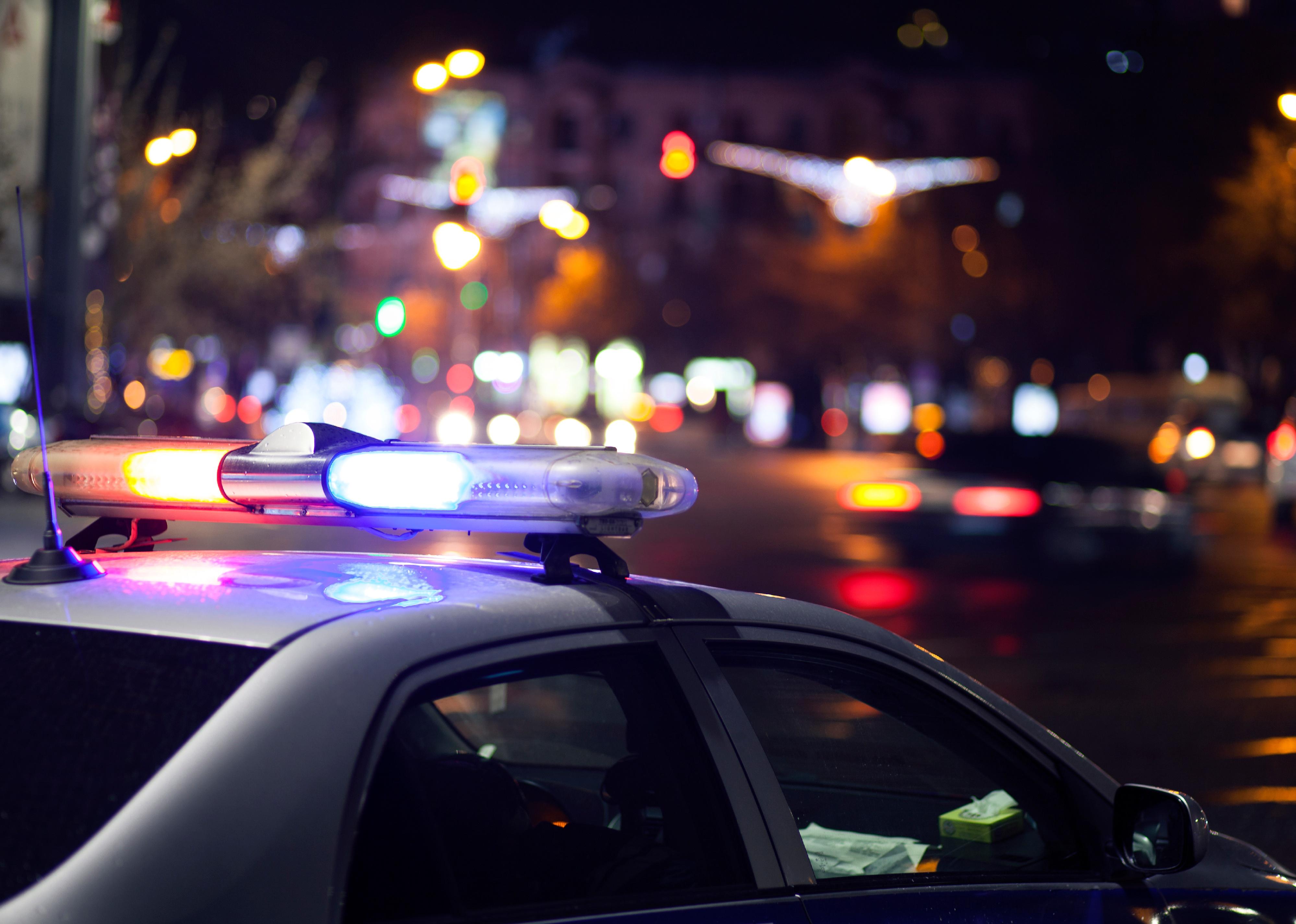 Blue flasher on the police car at night.