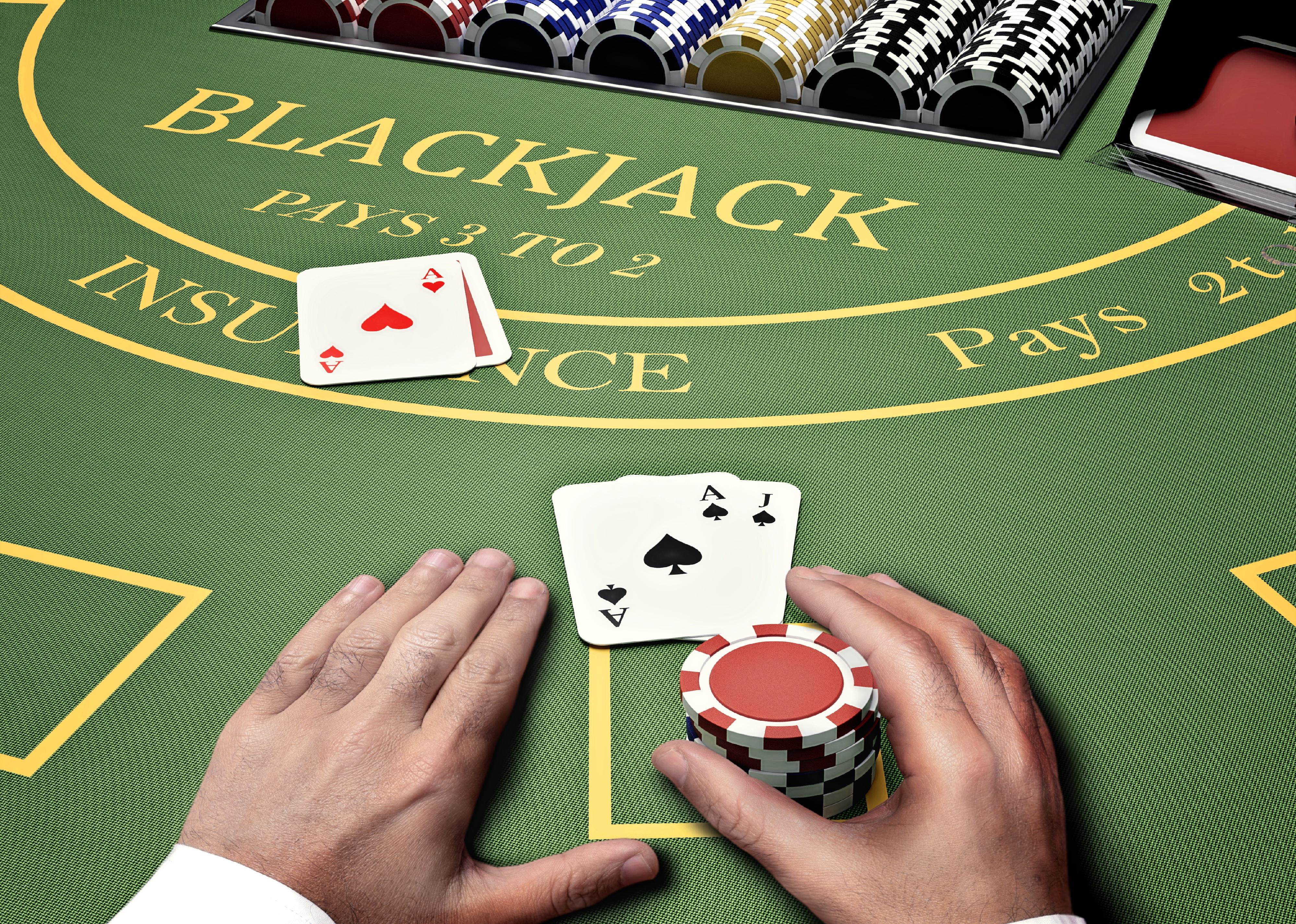 Closeup of hands on a blackjack table.