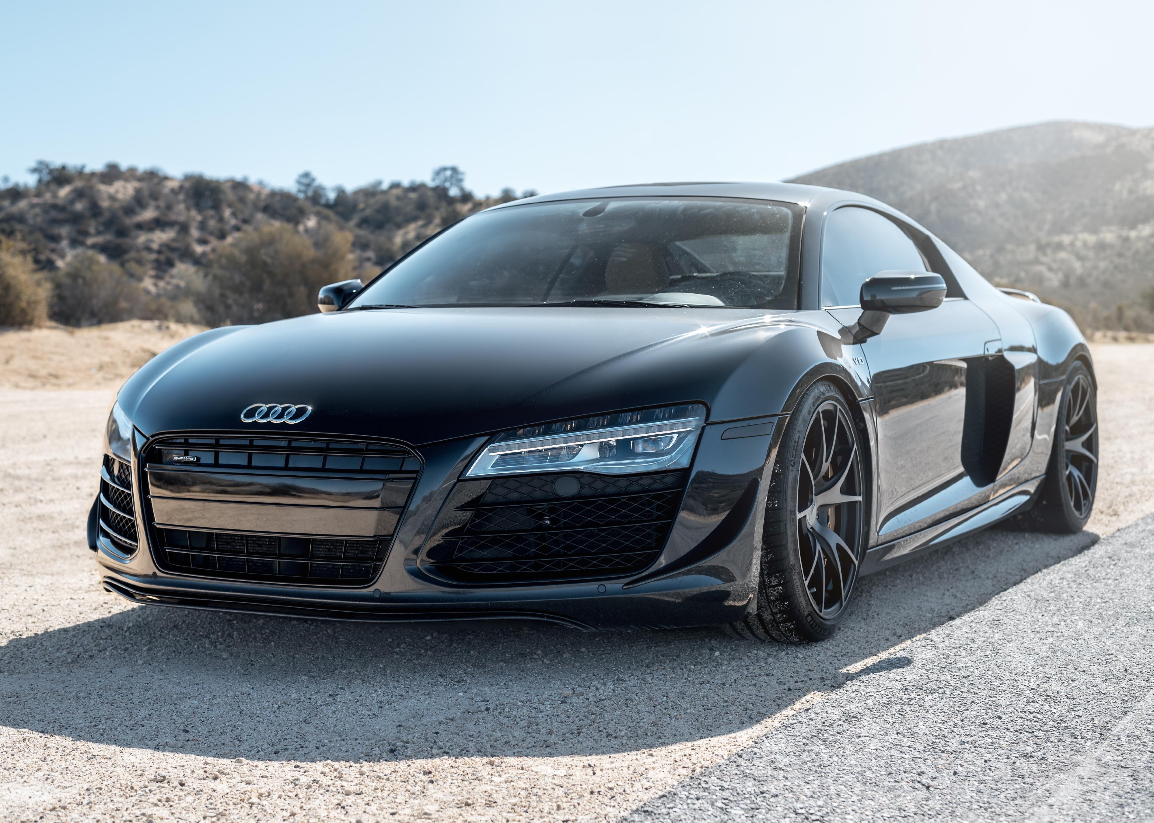 A black Audi R8 in the front of a mountain.