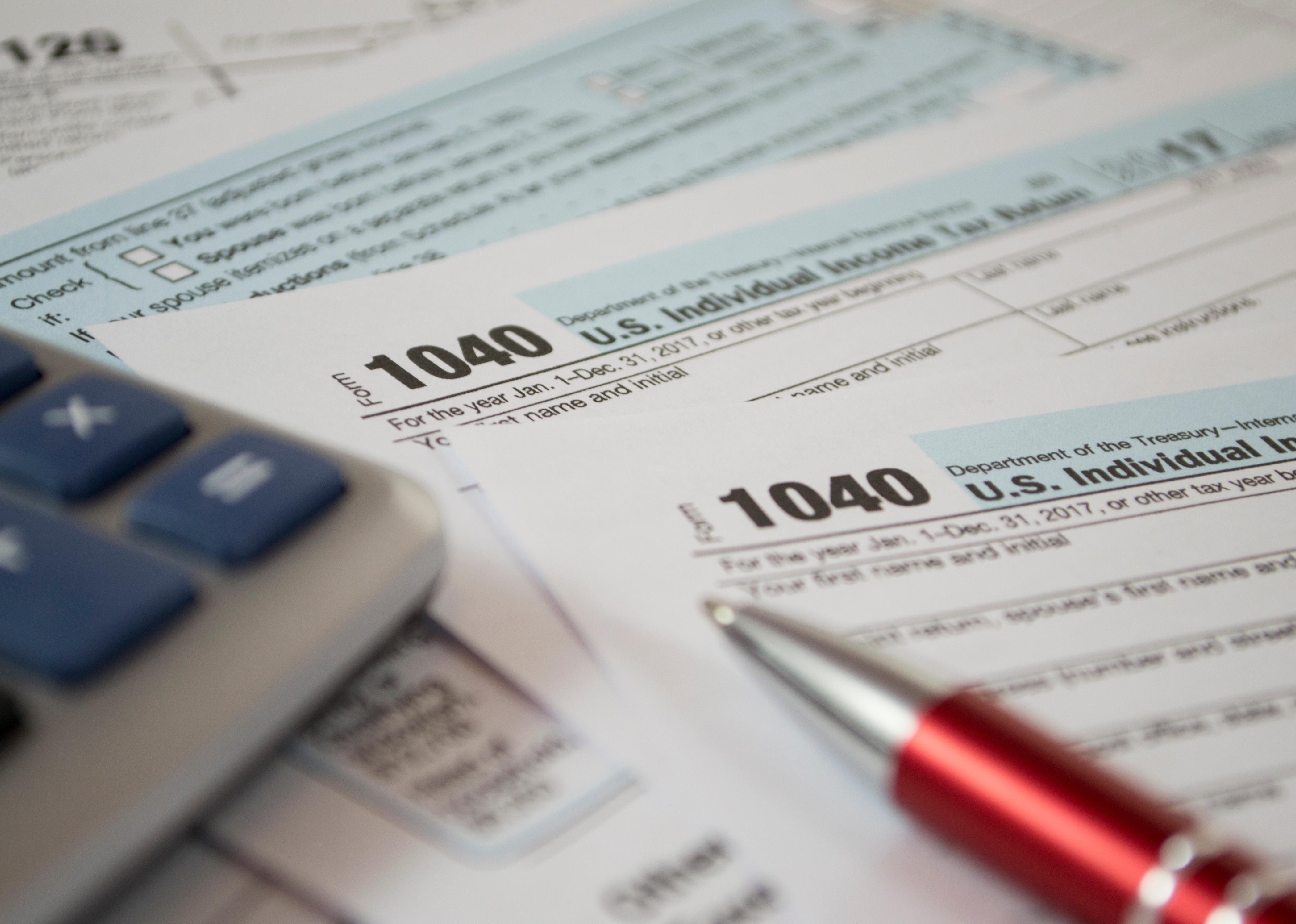 U.S. Individual income tax return, calculator and a pen.