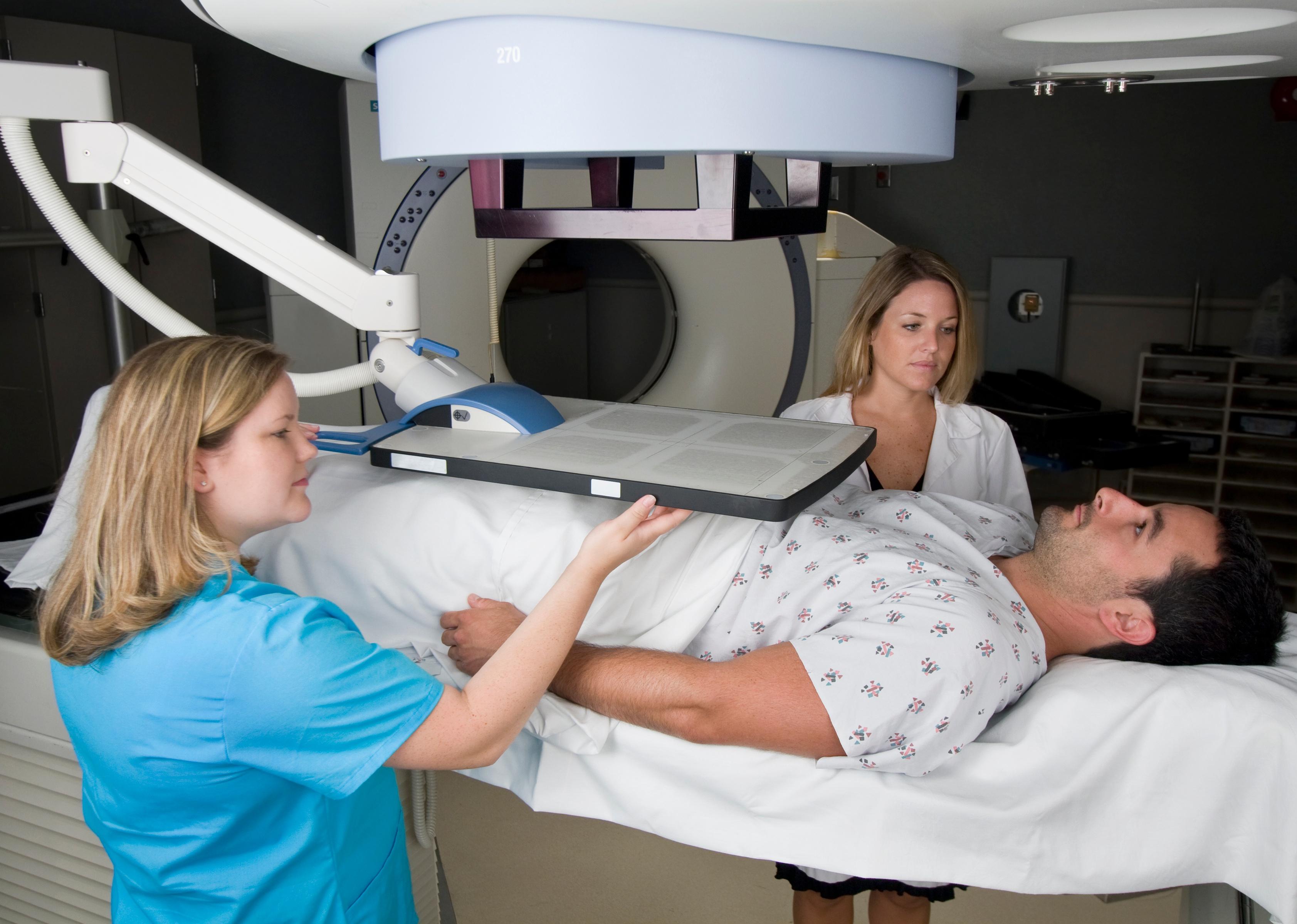 A dosimetrist gives radiation treatment to a patient.
