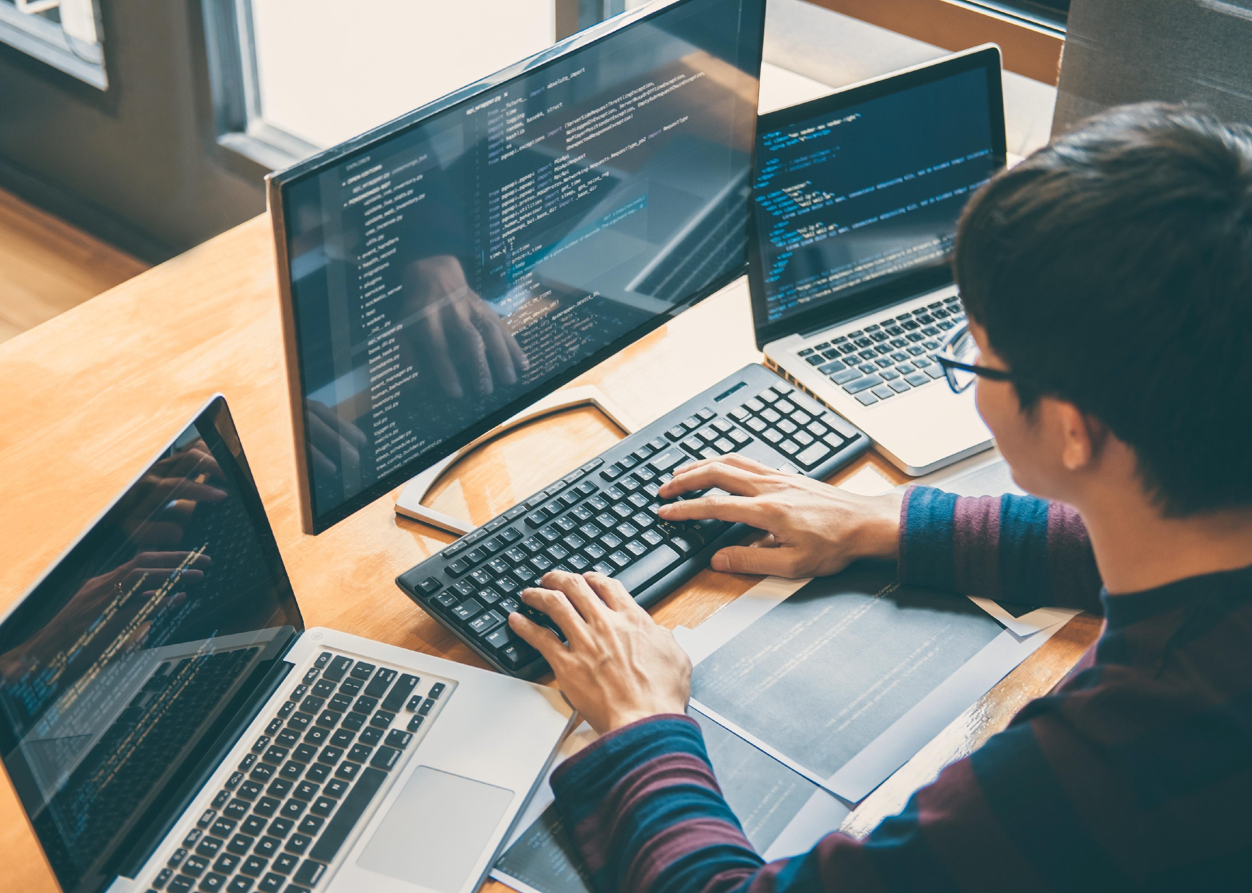 Programmer working on computers.