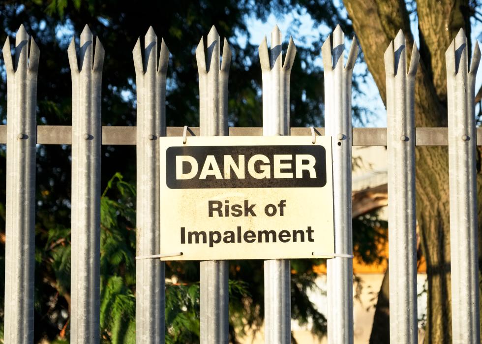 Impalement danger and risk sign on fence