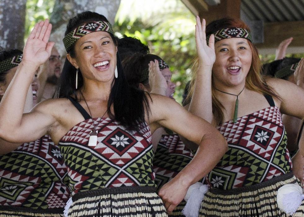 A small group of people dressed in traditional Maori clothing perform a dance.