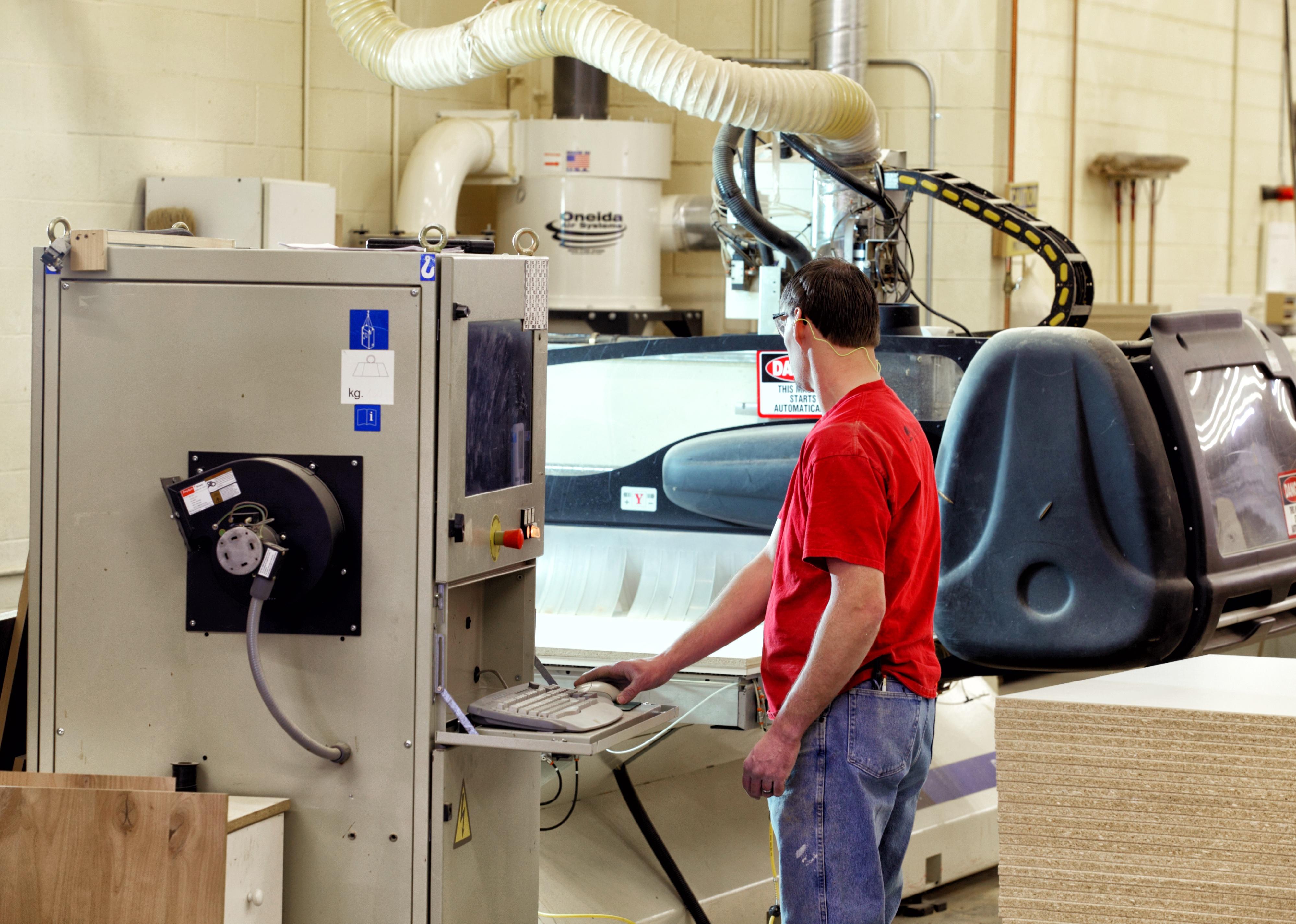 A worker operating a CNC router mill