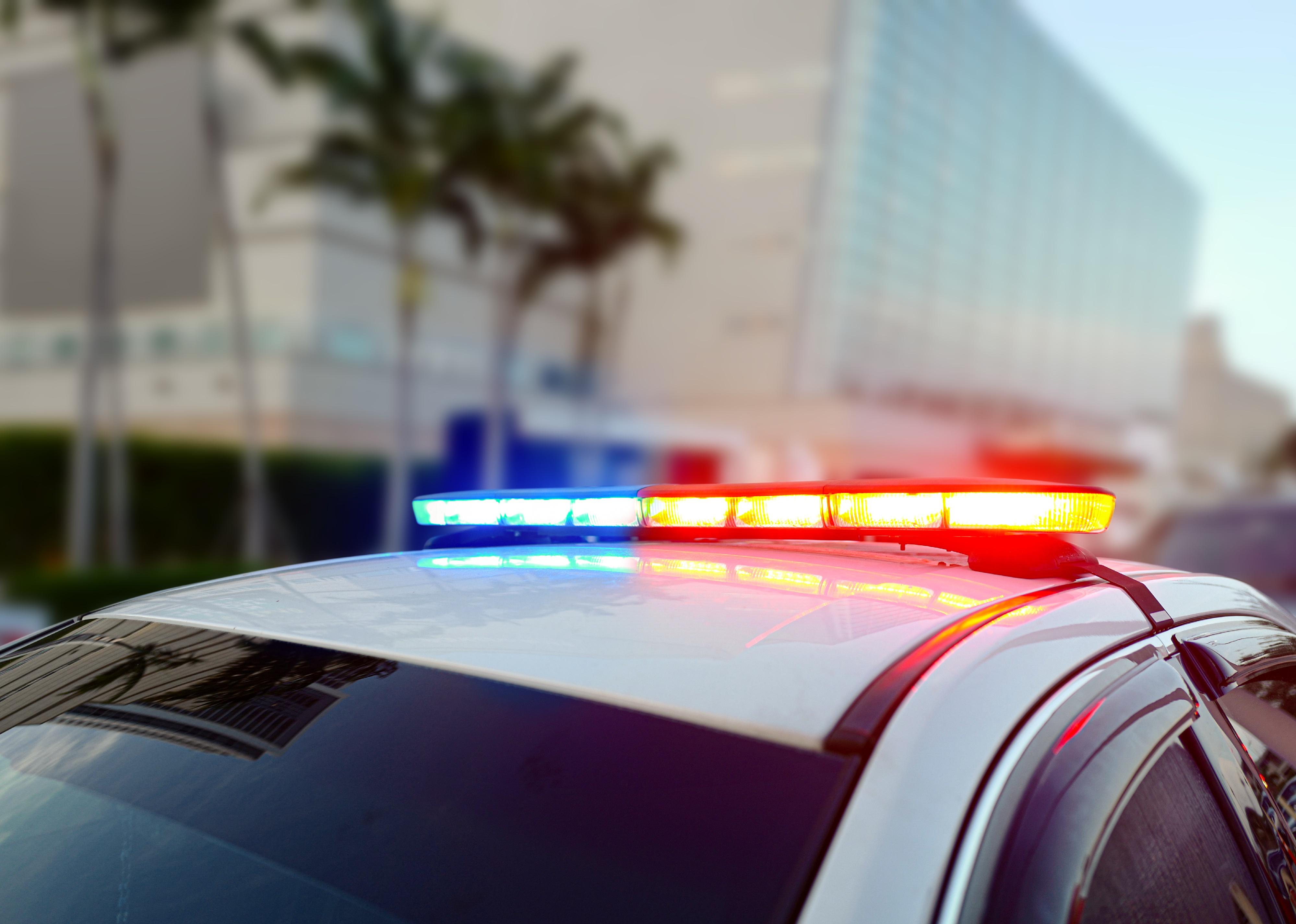 First responder police car, flashing a full array of blue and red tactical lights.