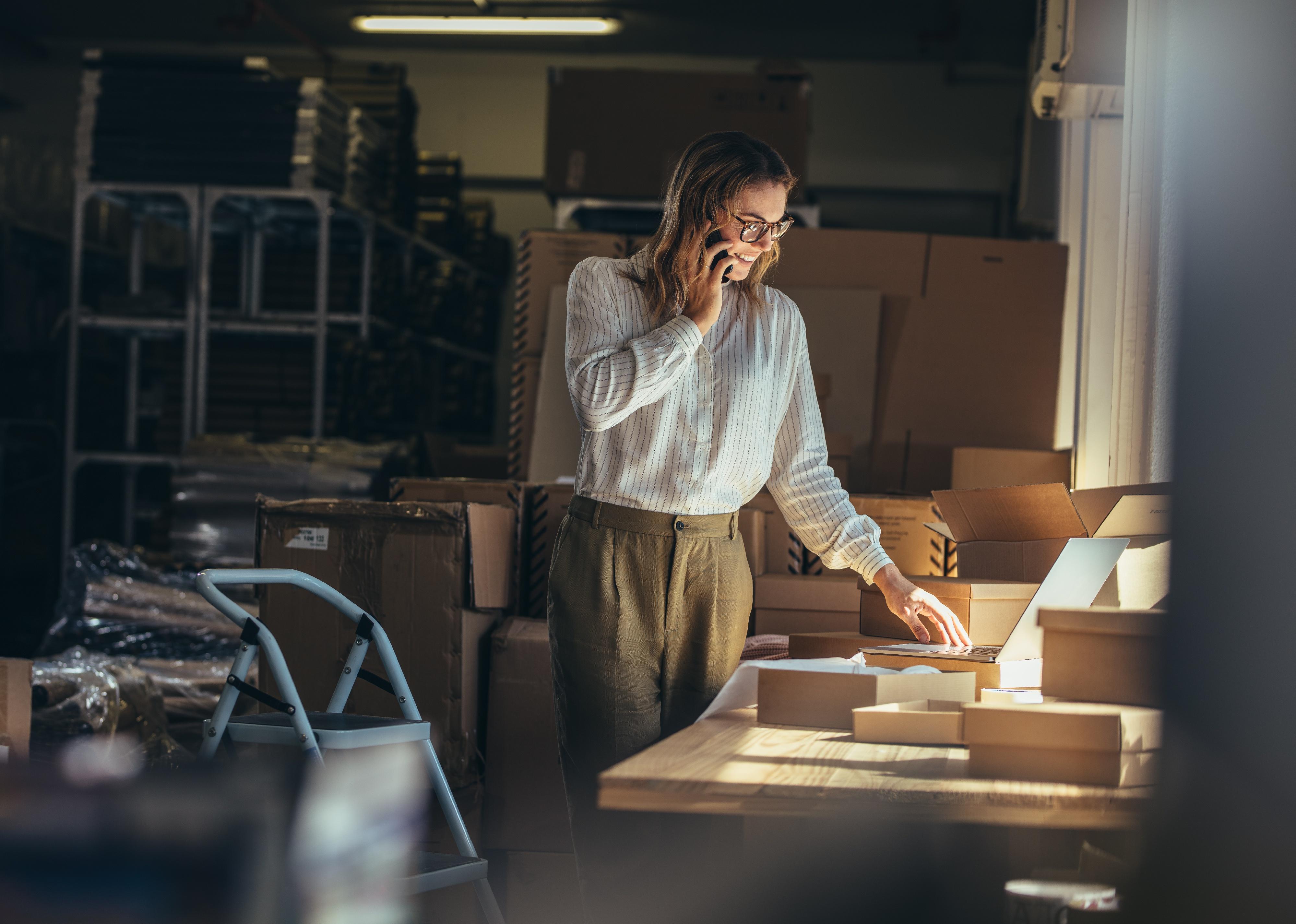 Woman seller on the phone in a warehouse.