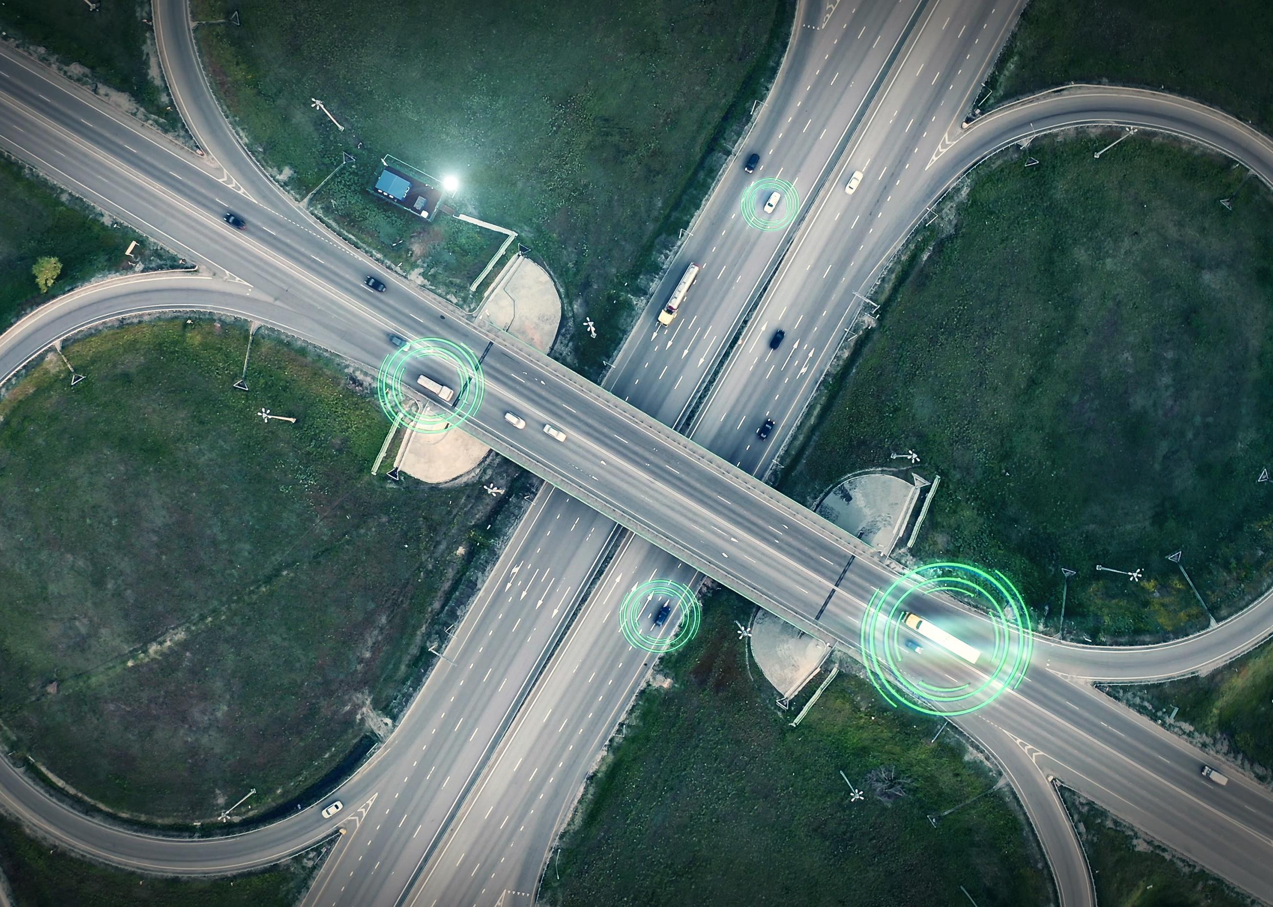 Aerial view of transport junction with cars driving with digital green circles.