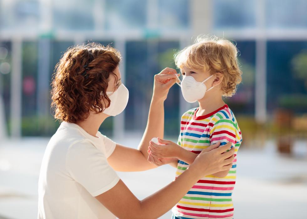 Mother and child putting on face masks.