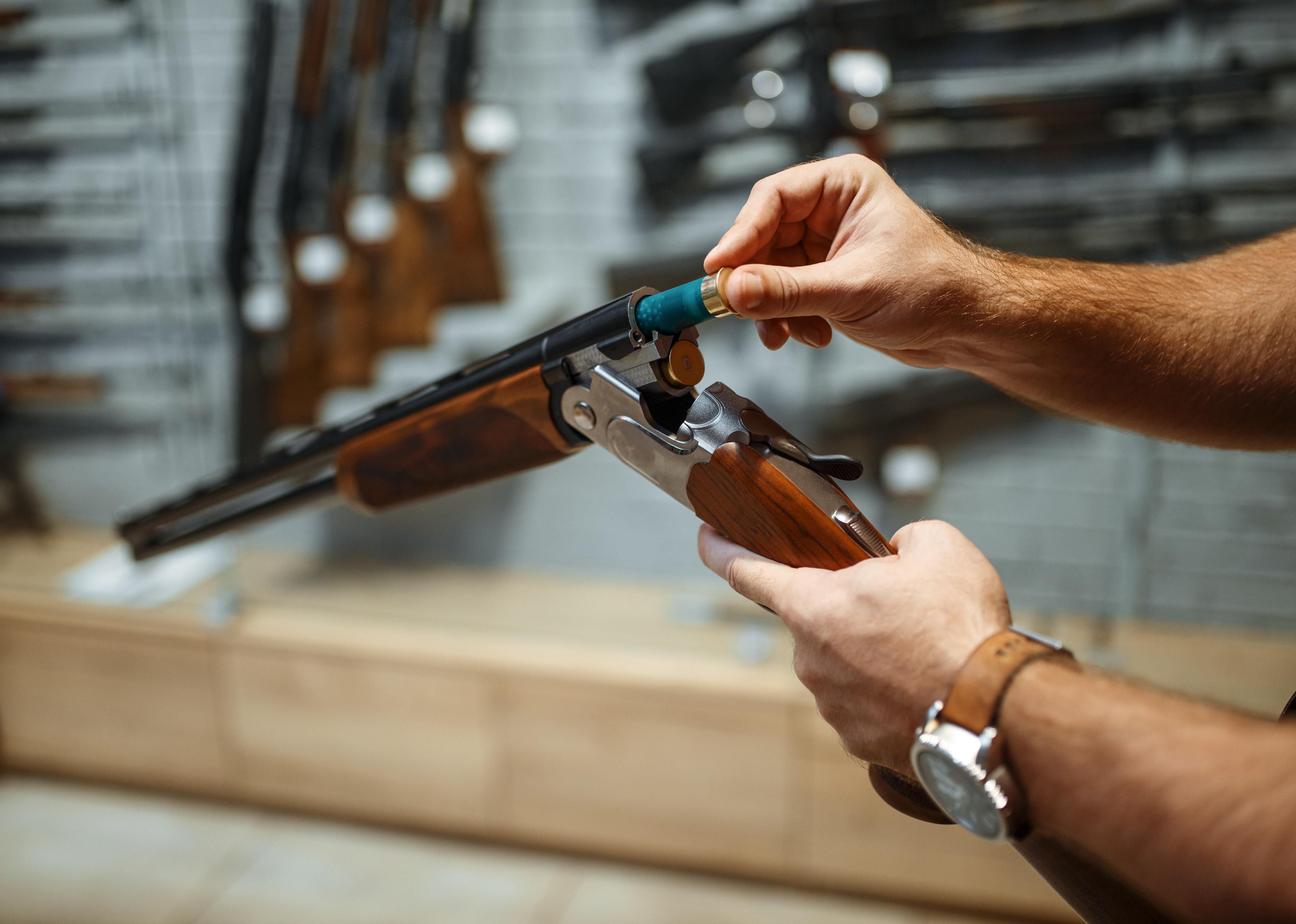 Person loads a rifle in a gun shop.