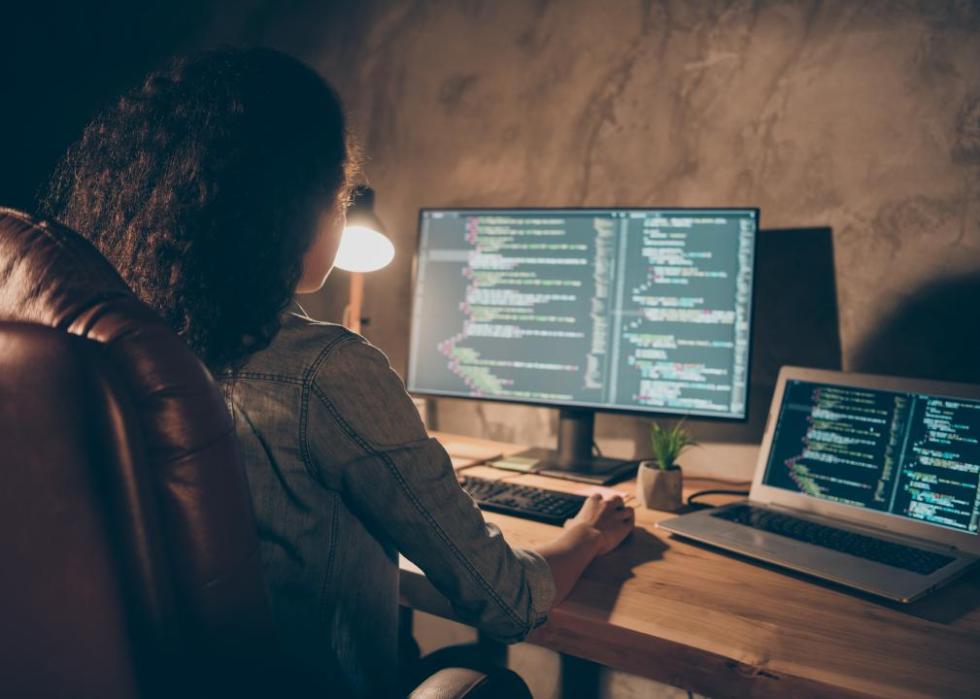 A woman looking at code on a computer.