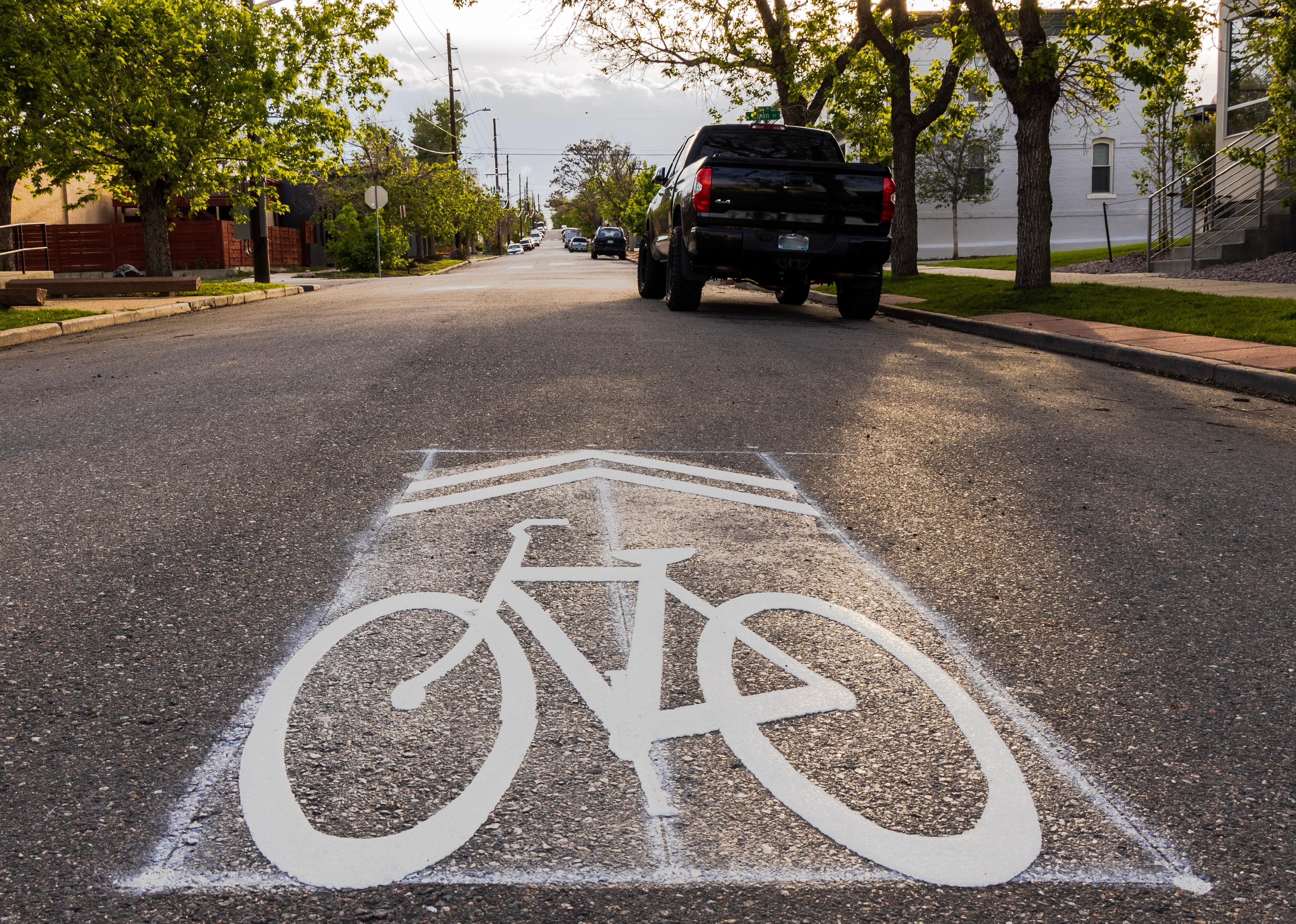 A road marked with a "sharrow," a painted picture of a bike.