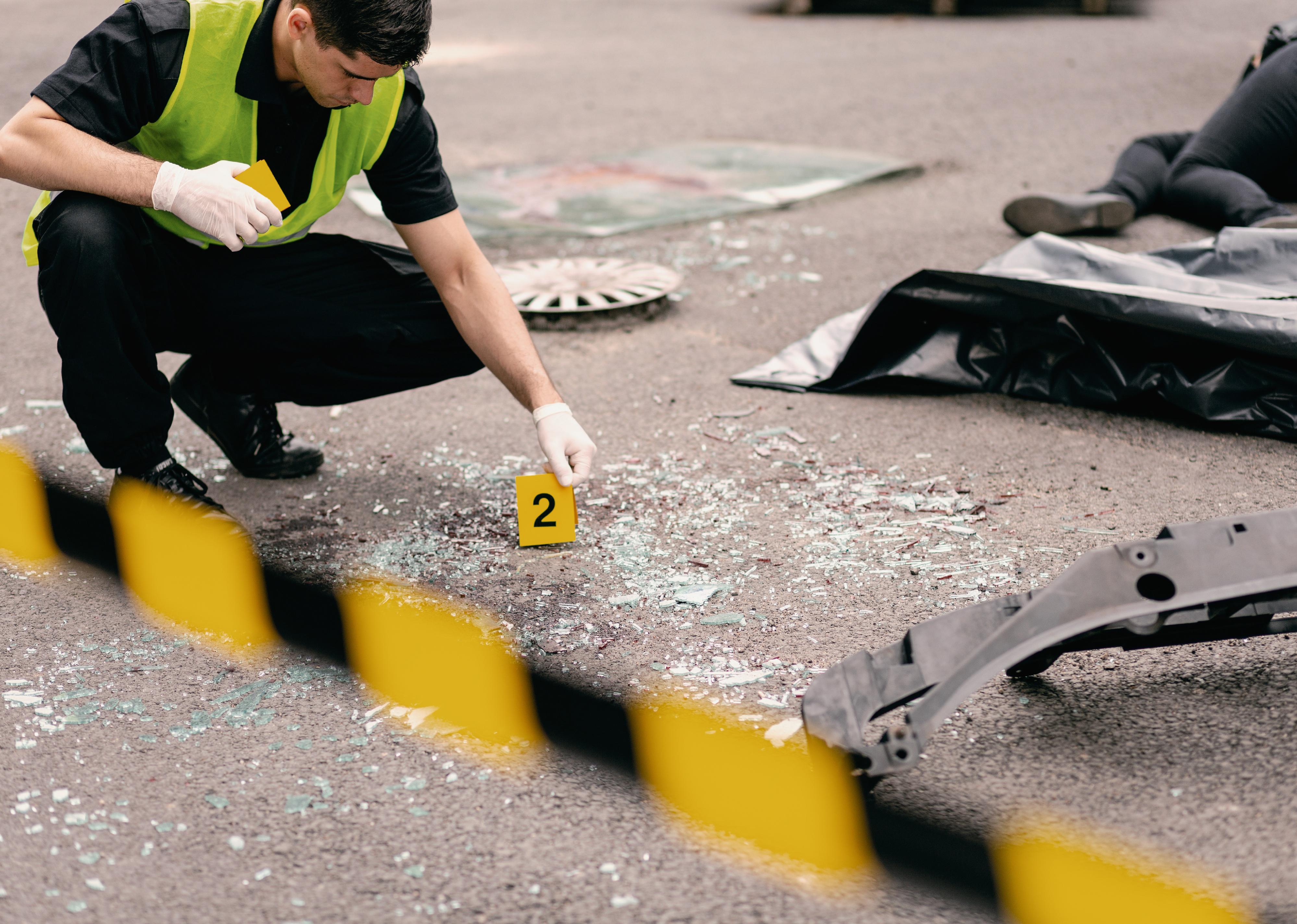 Close-up of policeman doing investigation at road accident area.