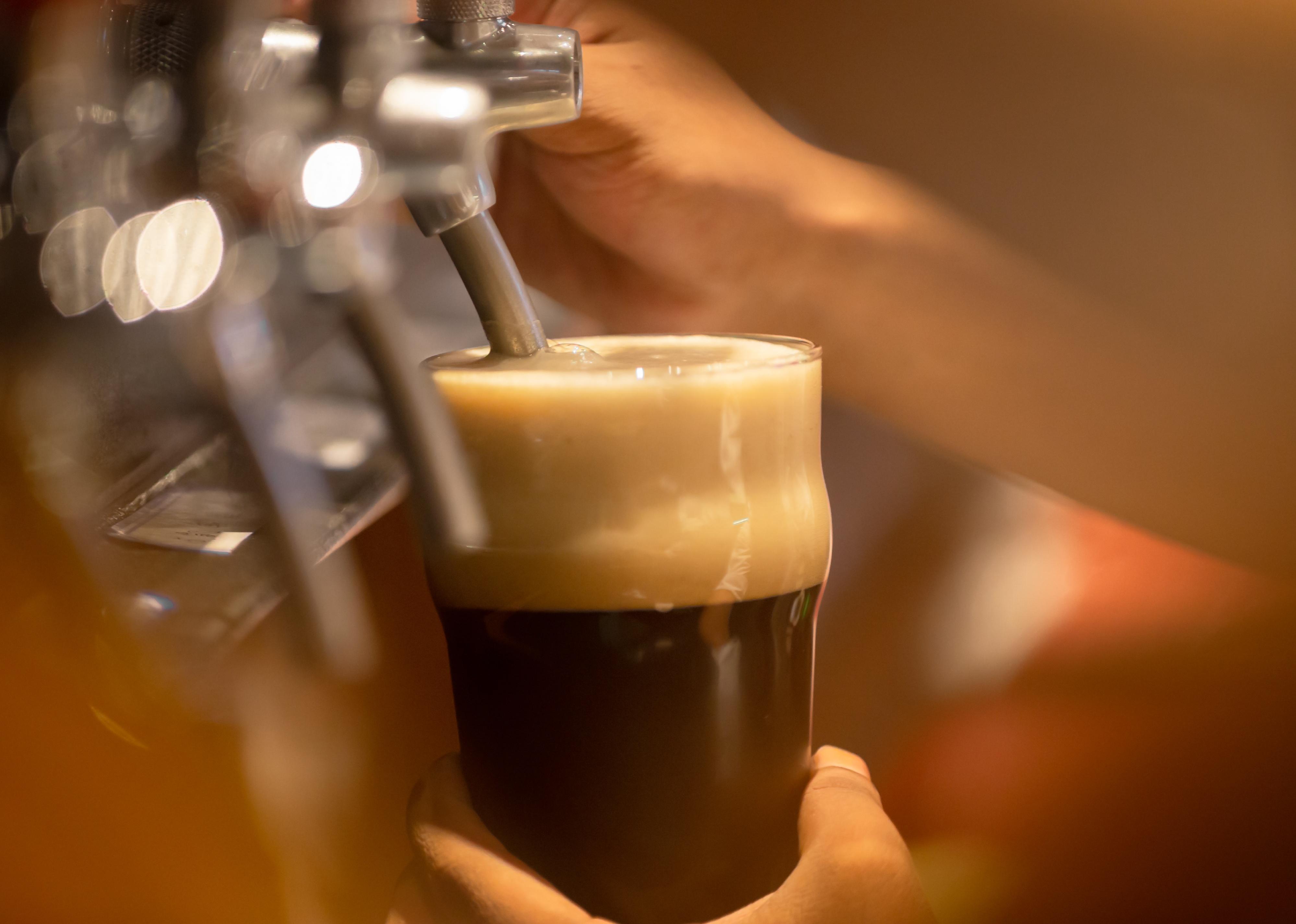 Stout beer pouring from a tap