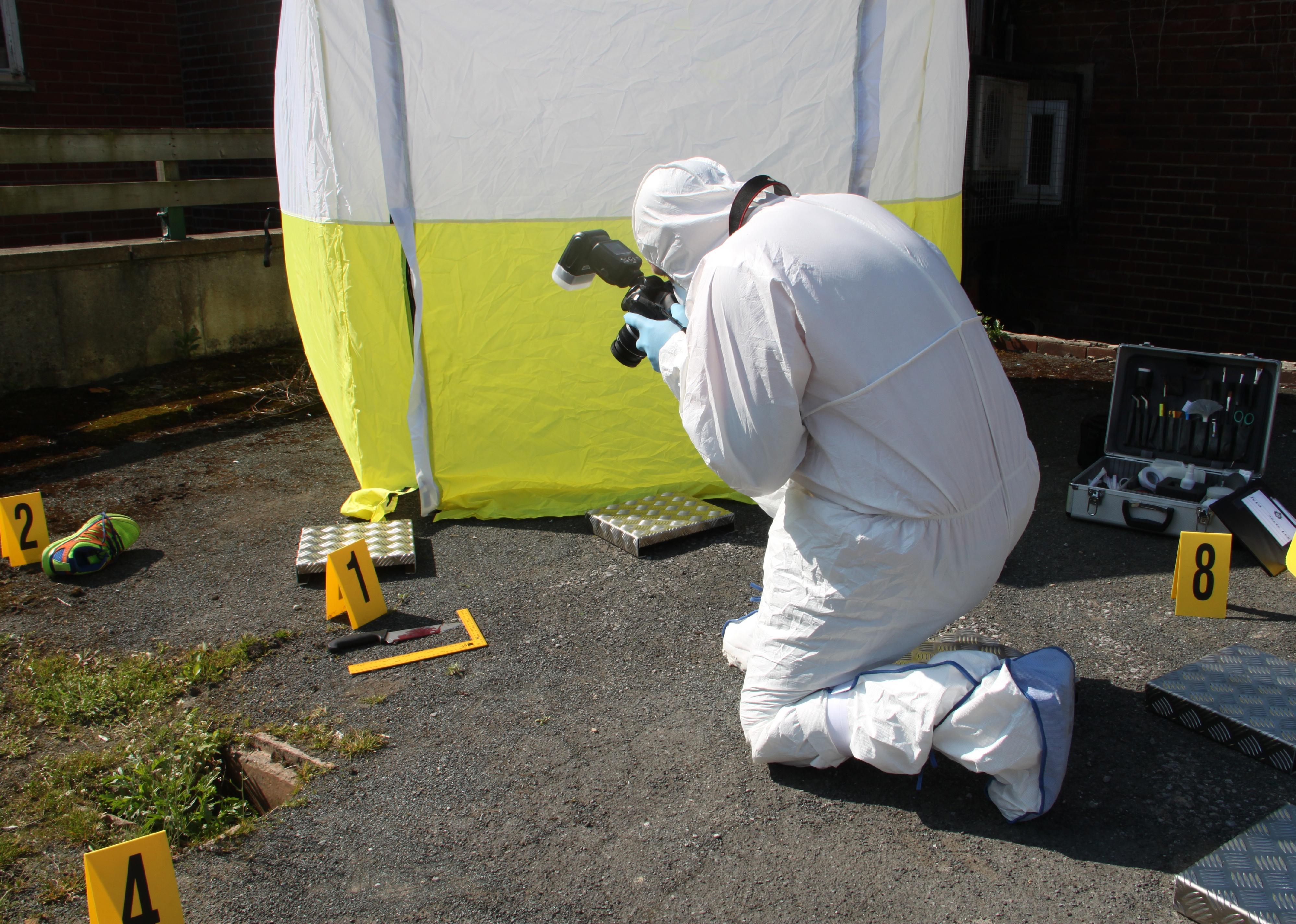 Investigator photographing crime scene.