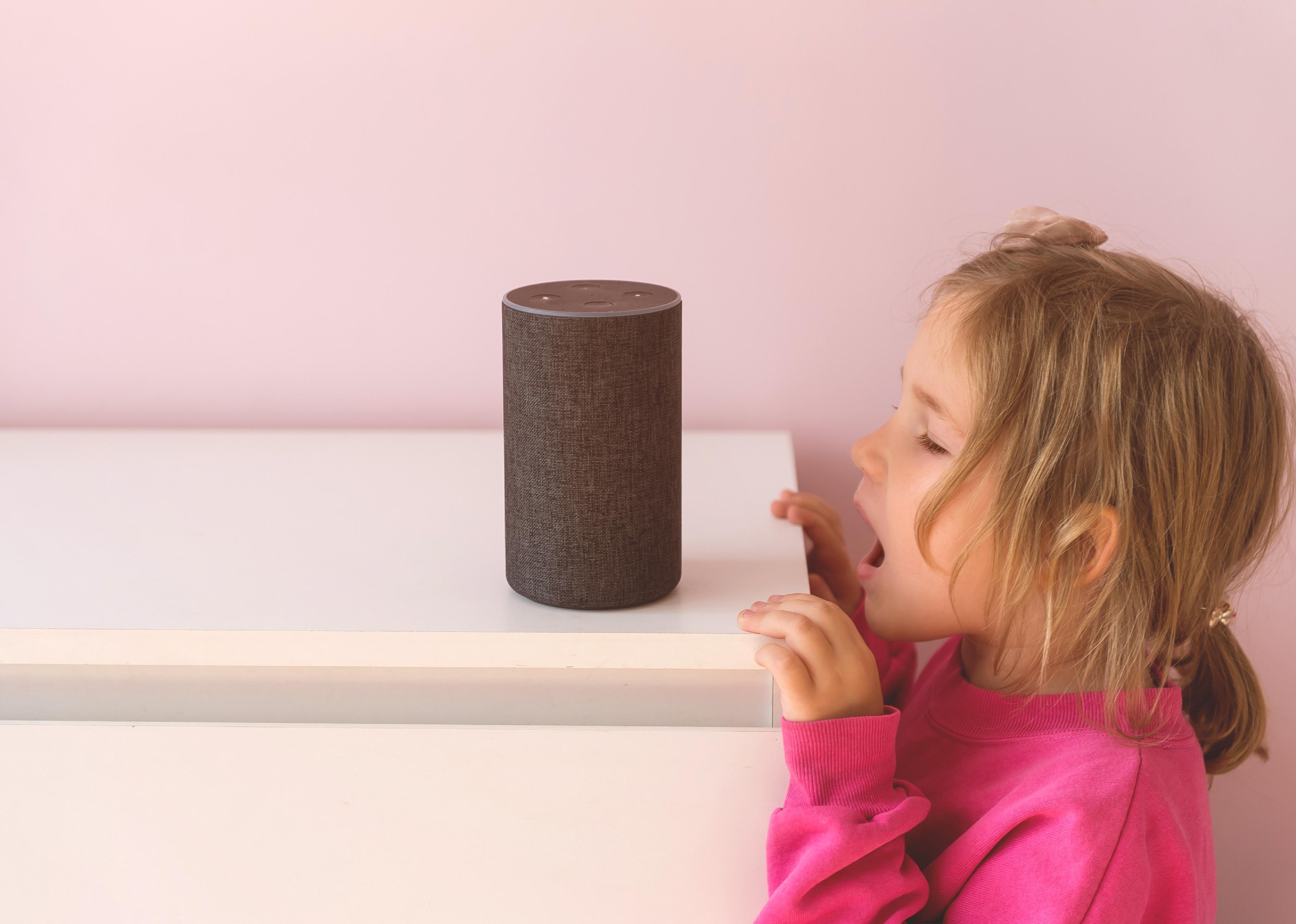 Little girl talking to Amazon Alexa.