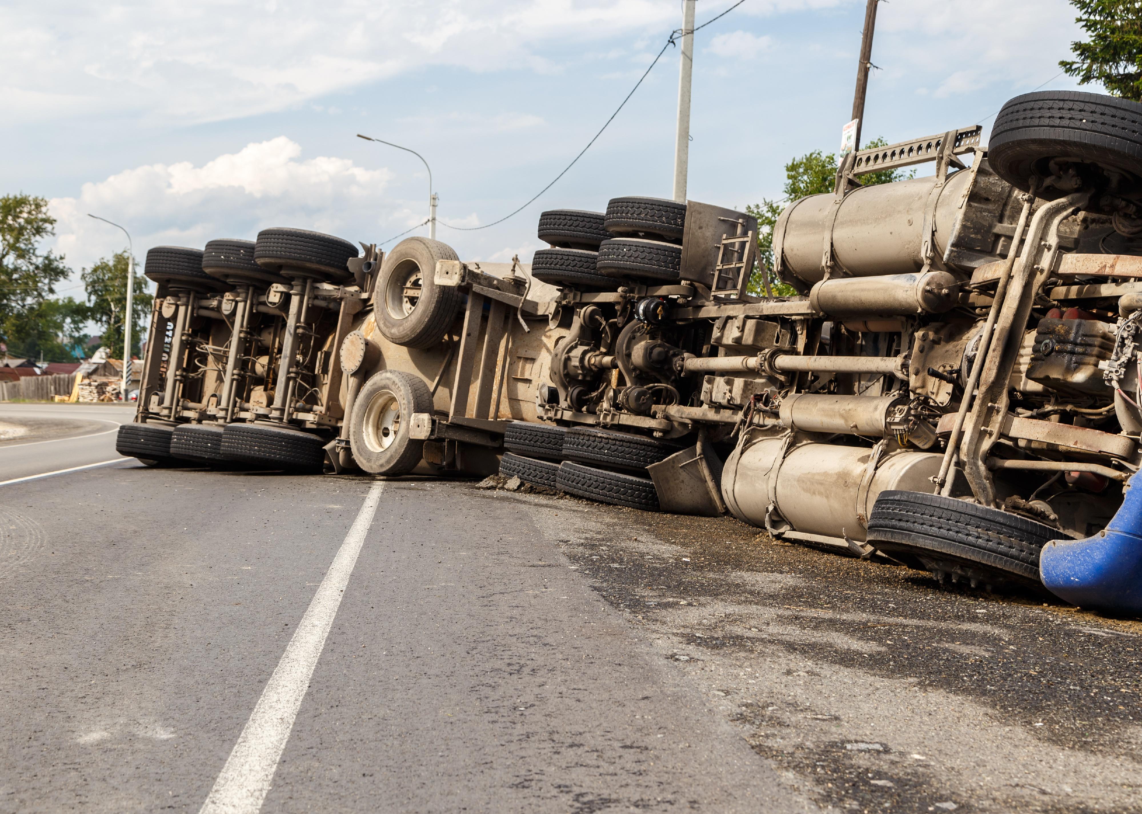A view of an overturned truck on an highway.