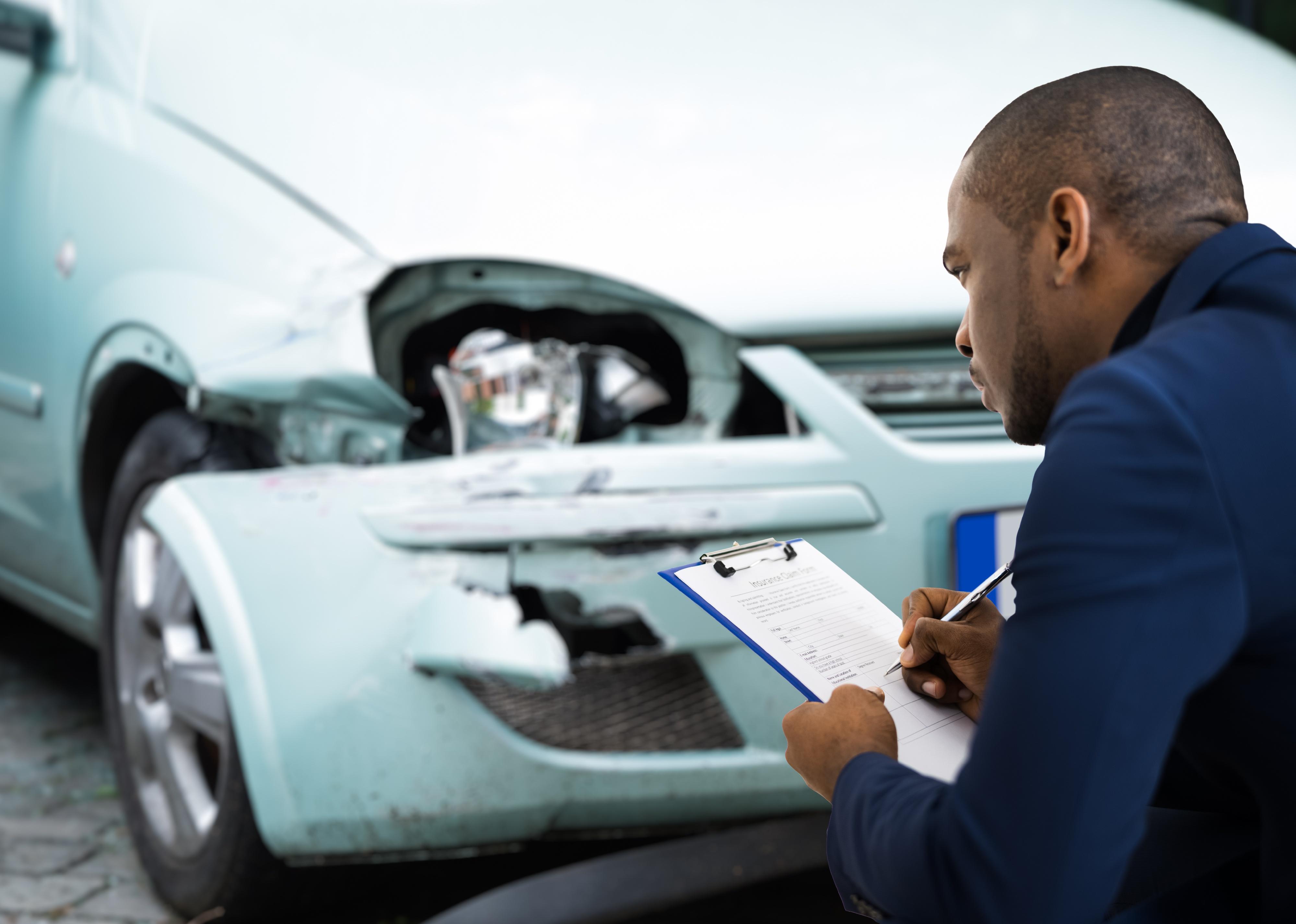 Car insurance agent inspecting accident claim