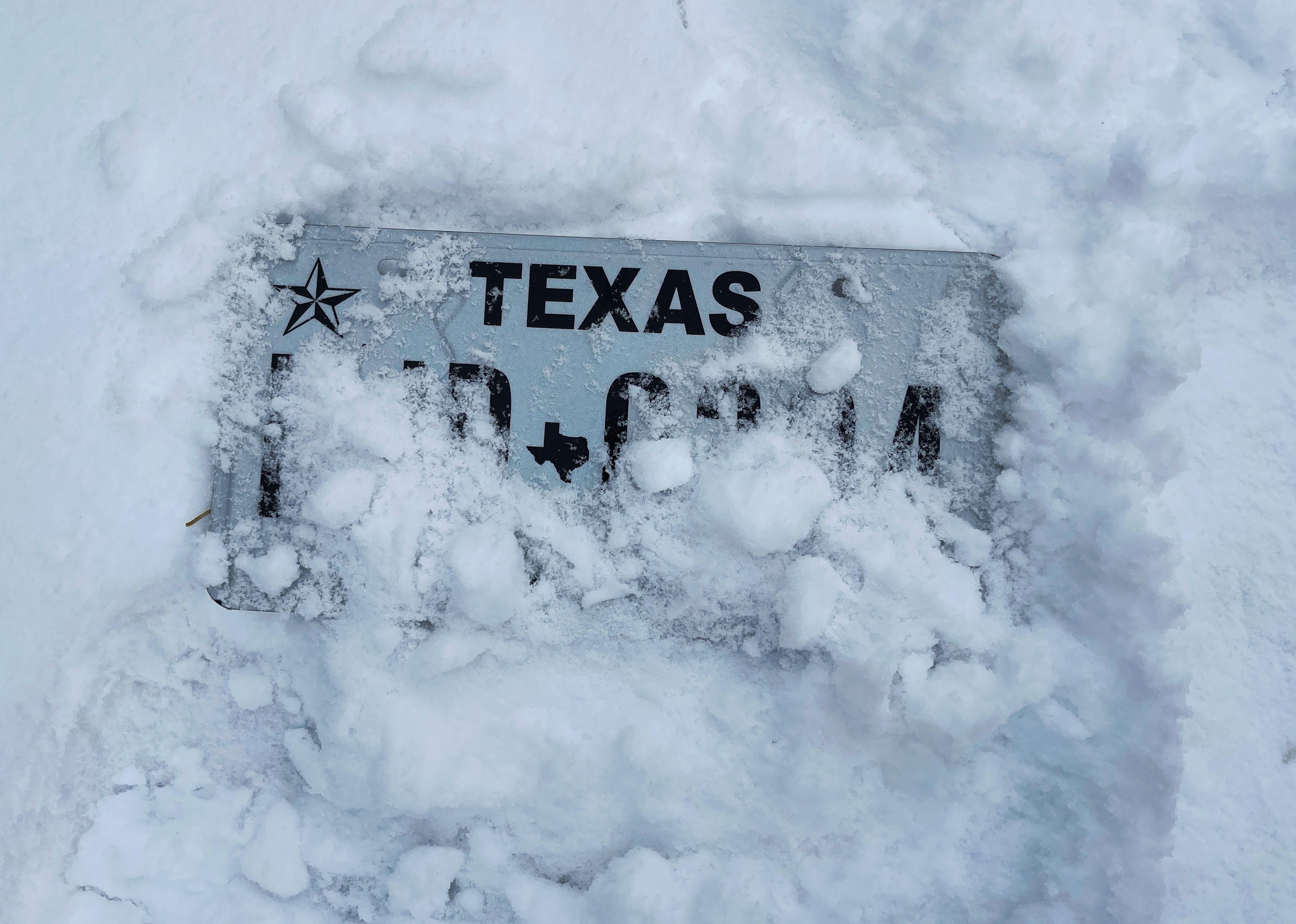 Texas license plate covered in snow.