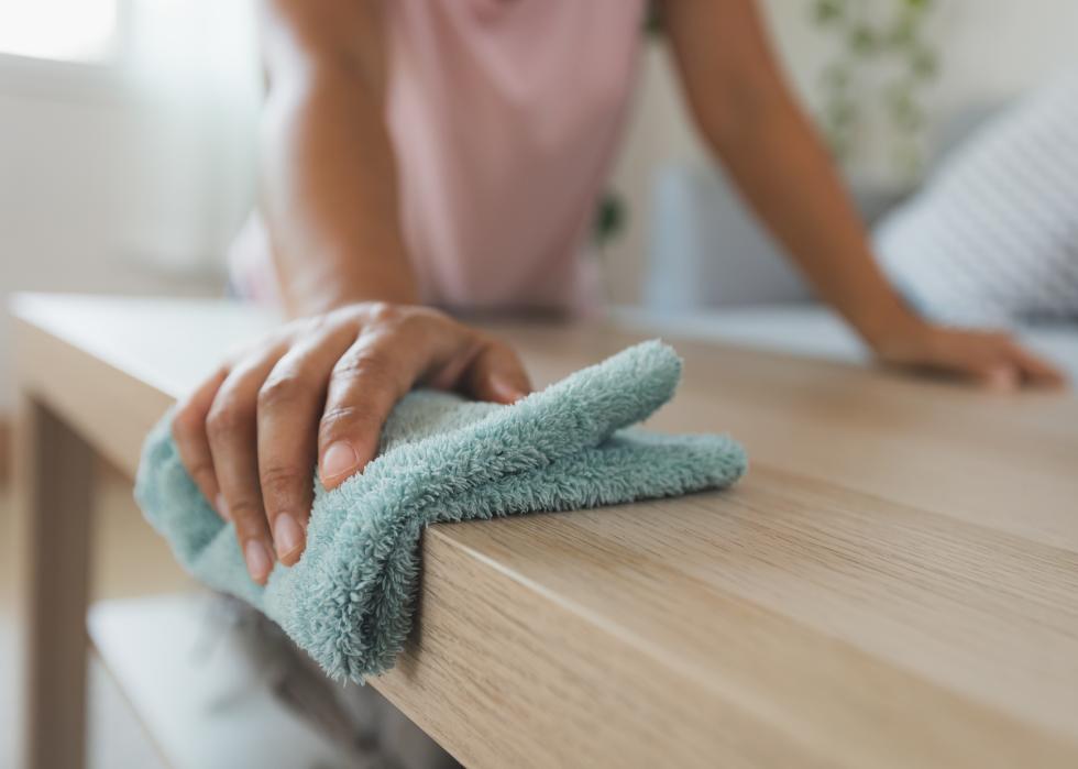 Woman cleaning a table with microfiber cloth