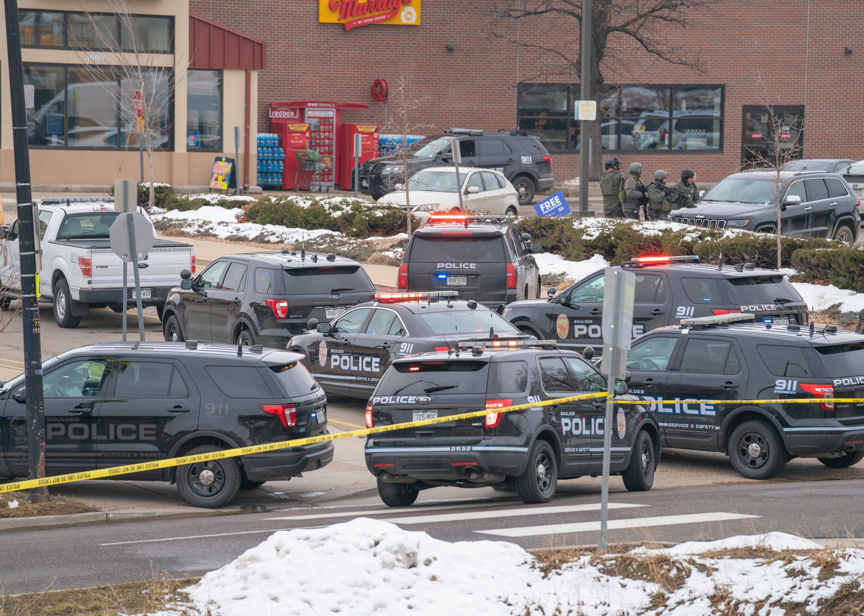 Police and SWAT officers in front of a shooting scene. 