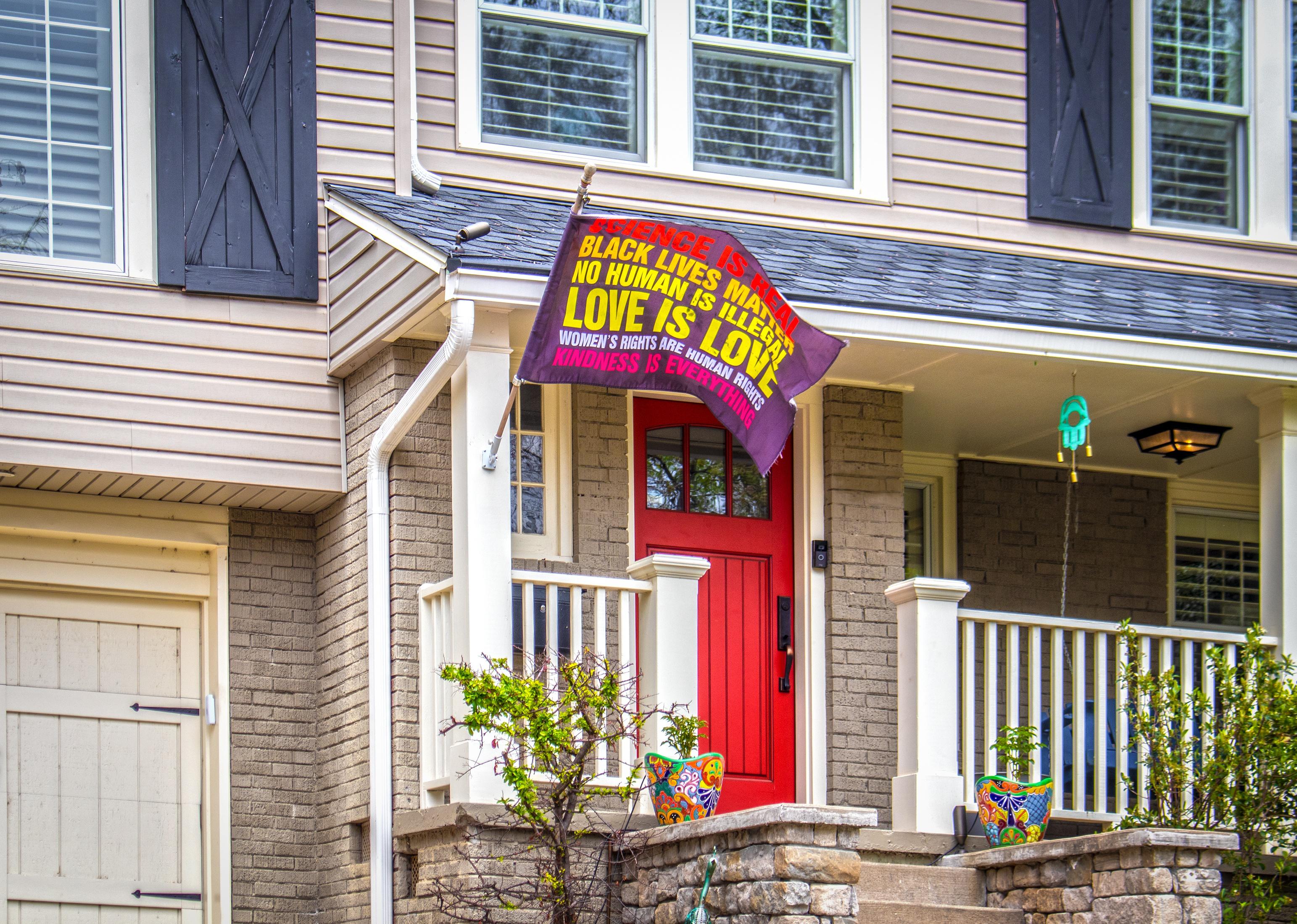 Brick house with BLM Love is Love flag flying from porch