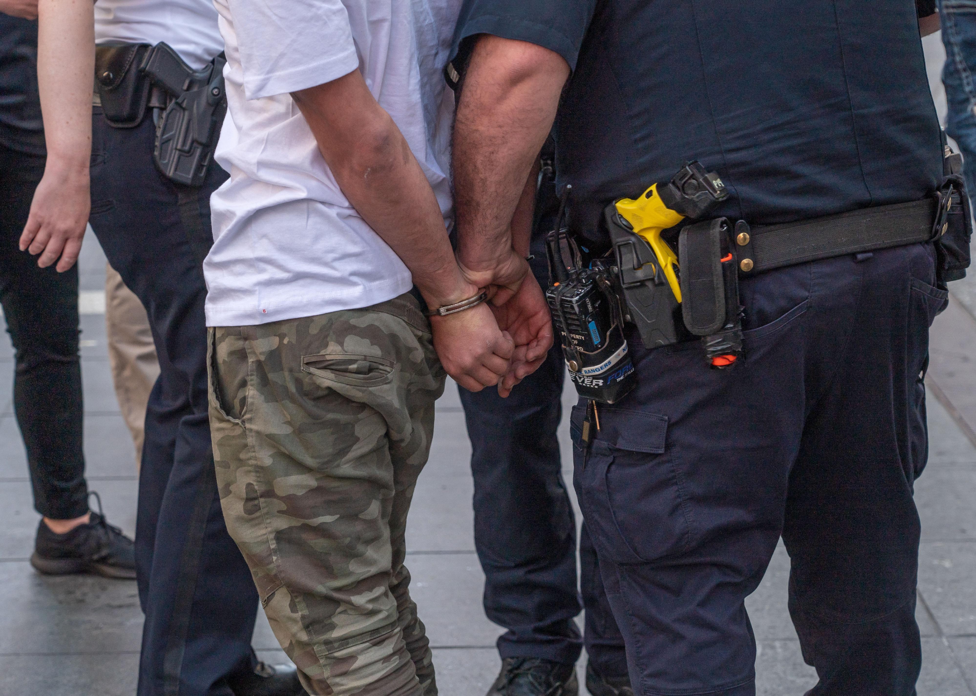 Officer with civilian in handcuffs.