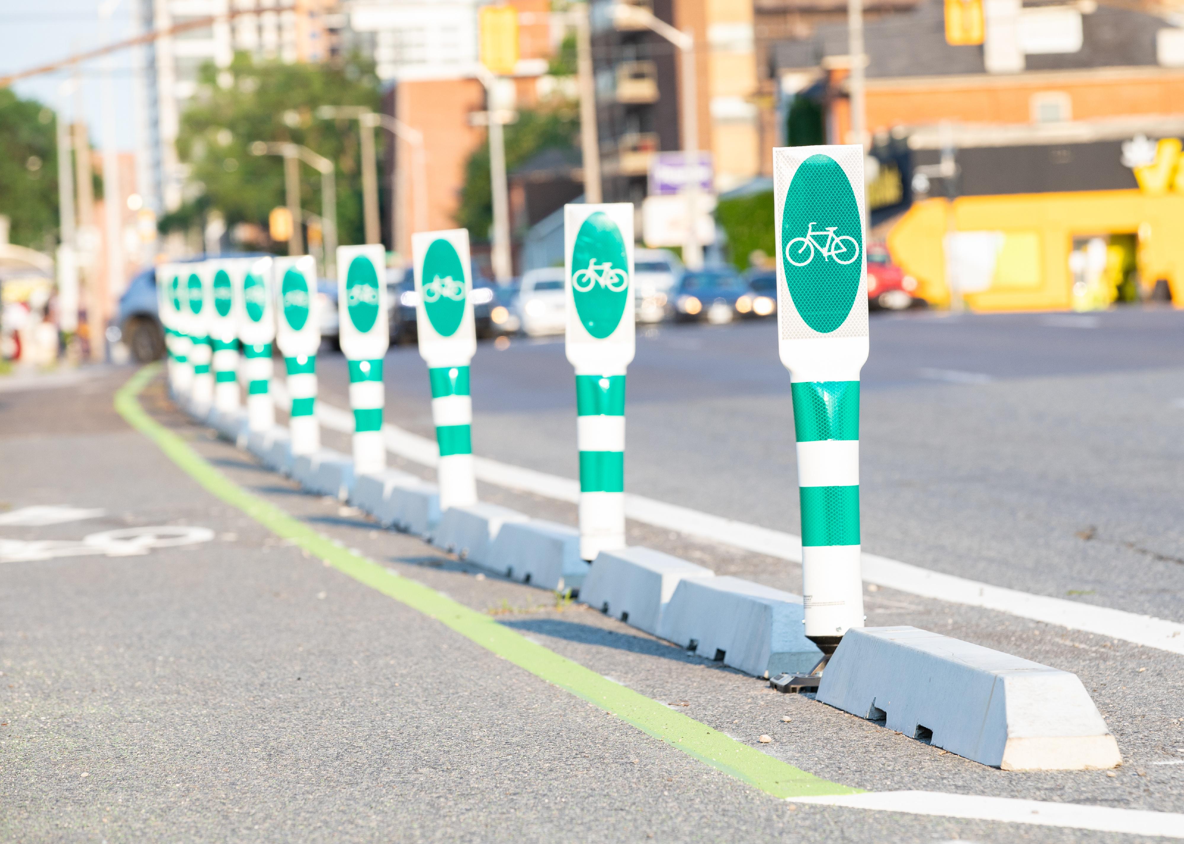 Safety barriers for bicycle lanes line a the street.