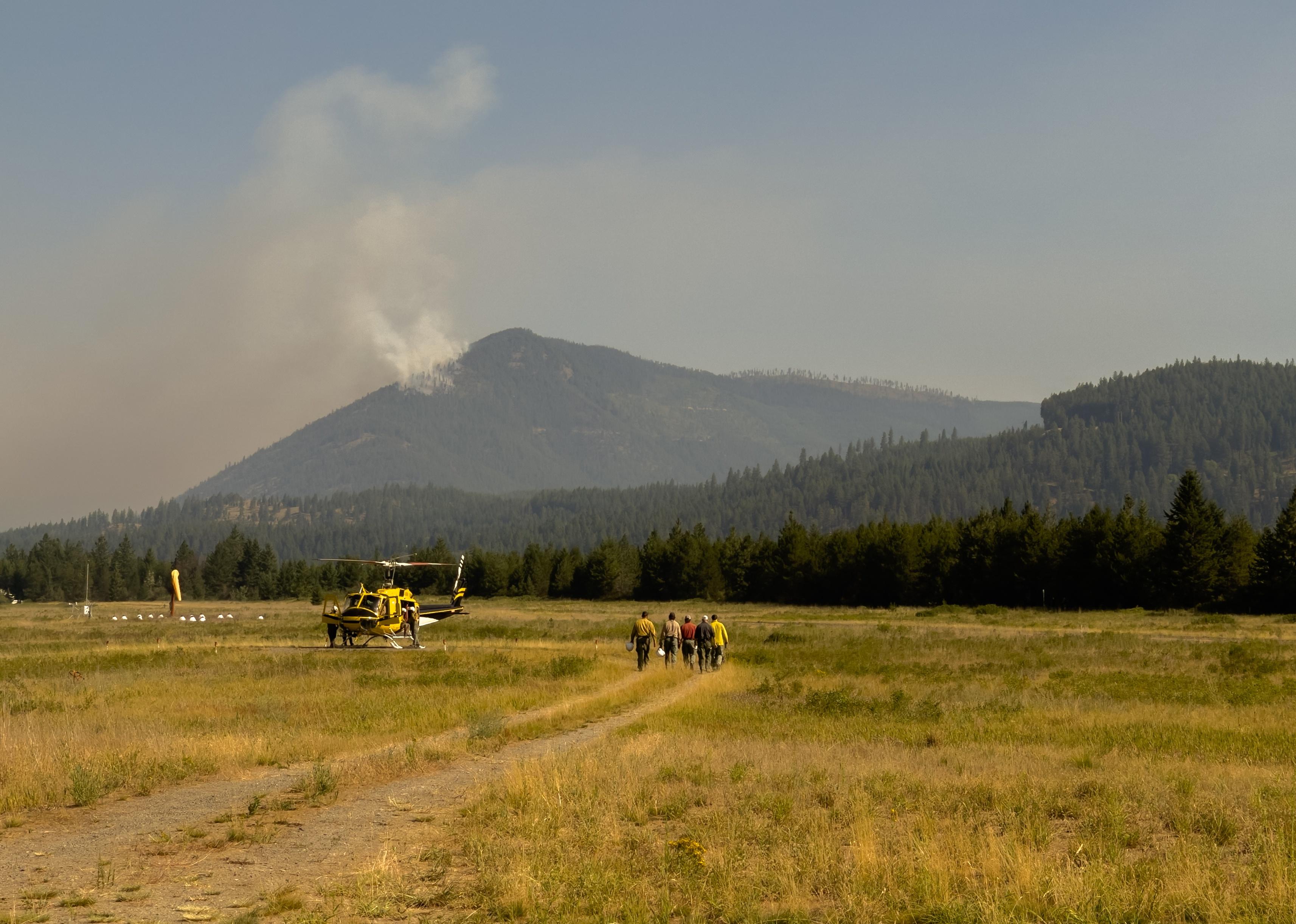Group of firefighters approach helicopter at Kootenai Forest fire.