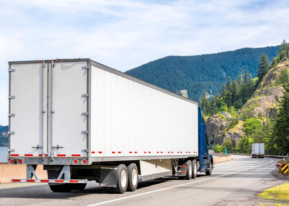 Back view of a semi driving up a road.