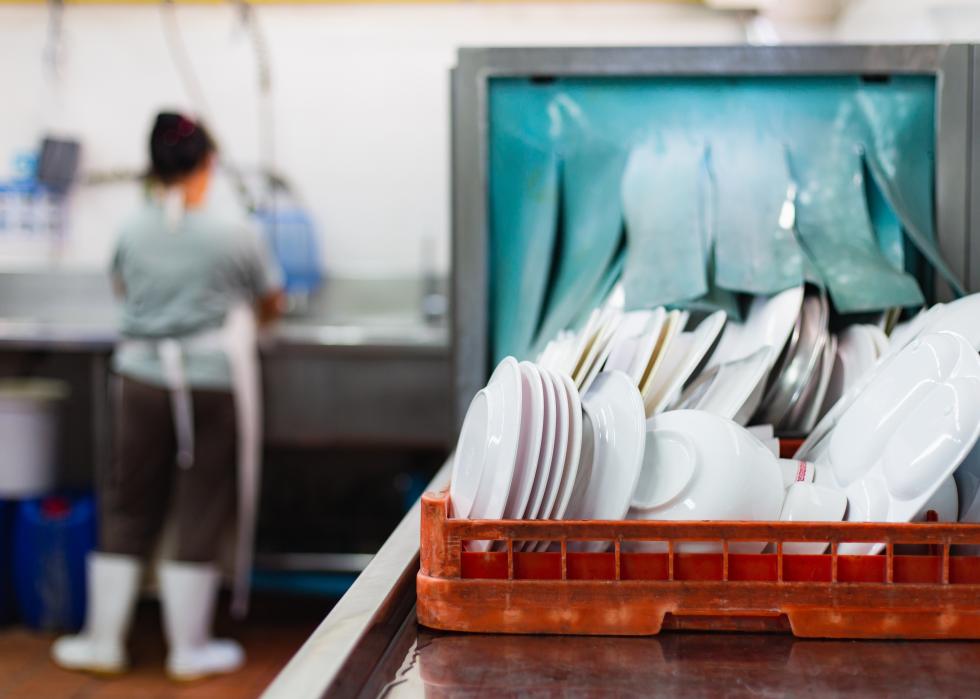 Dishwasher and staff at sink in restaurant.