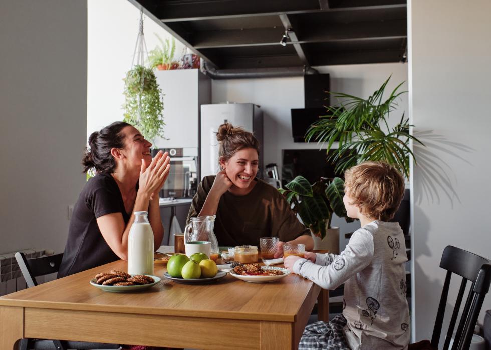 Happy family talking to child at table