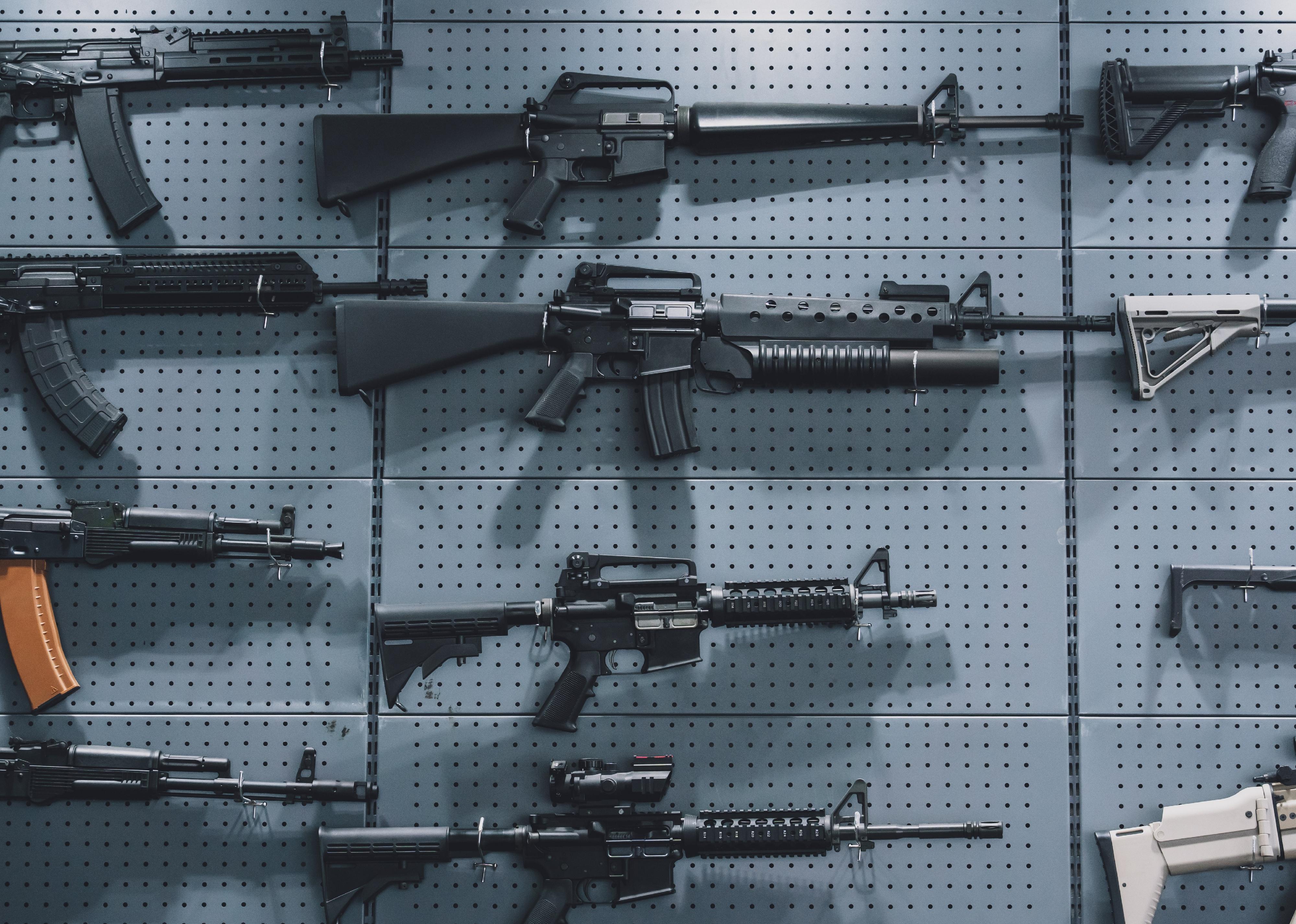 Collection of rifles and carbines on a wall.