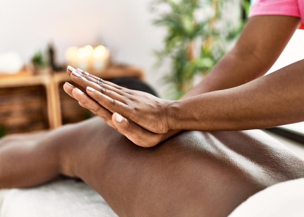 Close up of the hands of a massage therapist working on a man laying on a massage table.