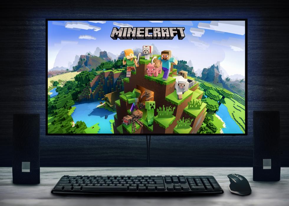 Minecraft video game logo on PC screen with keyboard, mouse and speakers.