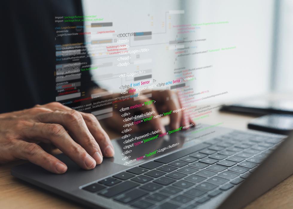 Software developer coding program with laptop.