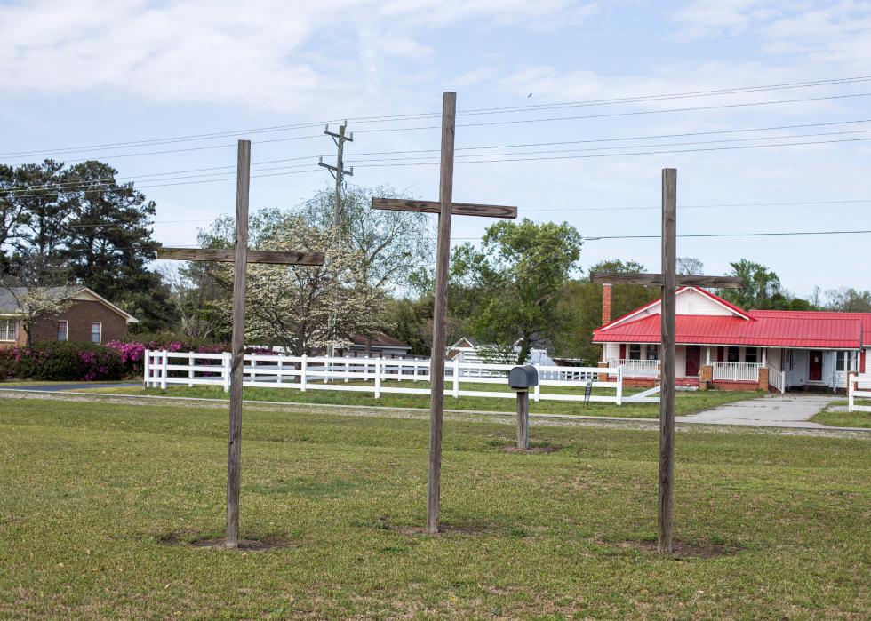 Three brown outdoor wooden crosses at a church in Laurinburg, North Carolina.